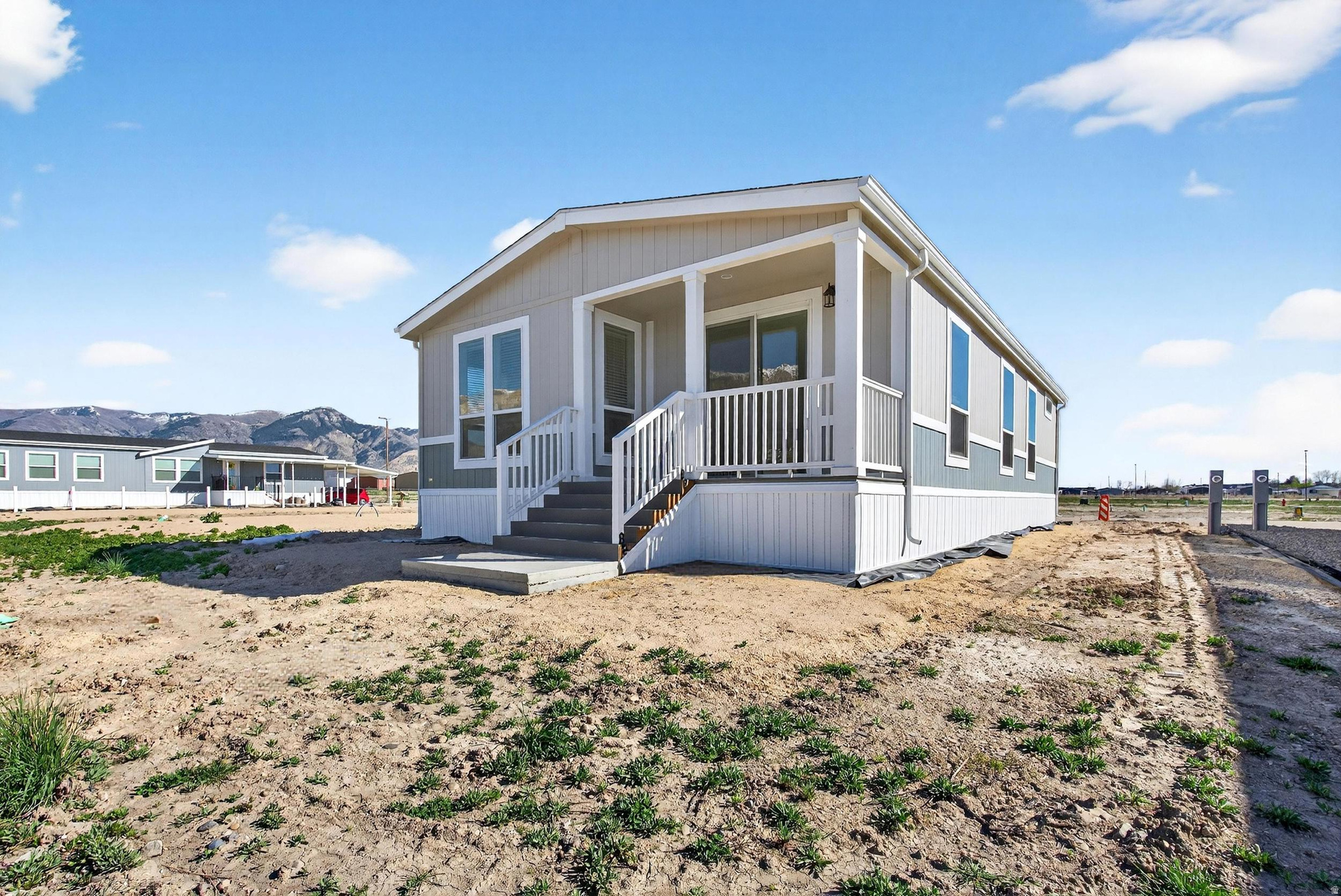Brand new, never lived in, and backed by one of the best views in the community. This beautifully finished manufactured home sits on the back row with a deck looking straight out to Ben Lomond Peak - mountain and water views that set this lot apart from the rest. The kitchen features bright cabinetry, stainless appliances, and a a large island, all opening to a bright, airy living space with LVP flooring throughout the main living area. The primary bath offers a glass walk-in shower and dual vanity - clean, modern, and move-in ready. First-owner opportunity at an accessible price point. Come see the view in person. Square footage figures are provided as a courtesy estimate only and were obtained from manufacturer building plans.  Buyer is advised to obtain an independent measurement.