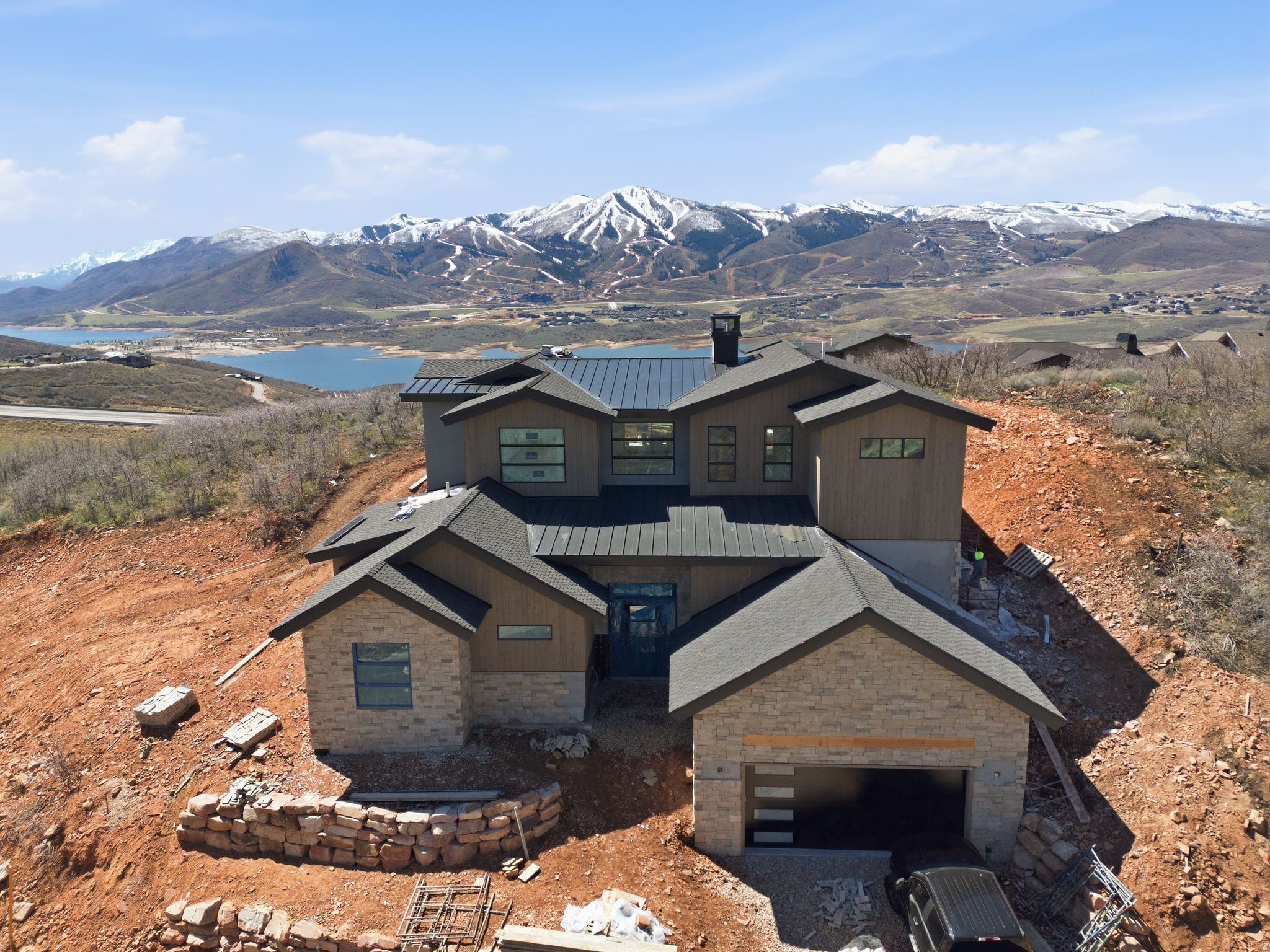 Completion in less than 30 days! If your wish list includes ski resort views, lake views, backing to open space, and generous living space, this is a must-see. Thoughtfully designed new construction in the desirable Soaring Hawk community, offering quality craftsmanship and elevated mountain living.  All five bedrooms feature ensuite baths, providing comfort and privacy for family and guests alike. Expansive windows and sliding doors frame stunning views of nearby ski resorts, Jordanelle Reservoir, and even Deer Creek in the distance, while filling the home with natural light.  Enjoy seamless indoor-outdoor living from the private covered deck, perfectly positioned to capture the surrounding open space and serene setting. Wood flooring runs throughout the main living areas, complemented by tasteful tile selections in bathrooms, mudroom, and laundry spaces.  Ideally located just minutes from Park City, Historic Main Street, world-class skiing, the expanded Deer Valley East Village, and year-round recreation at Jordanelle Reservoir-this home delivers the ultimate Park City lifestyle where comfort, views, and convenience come together.