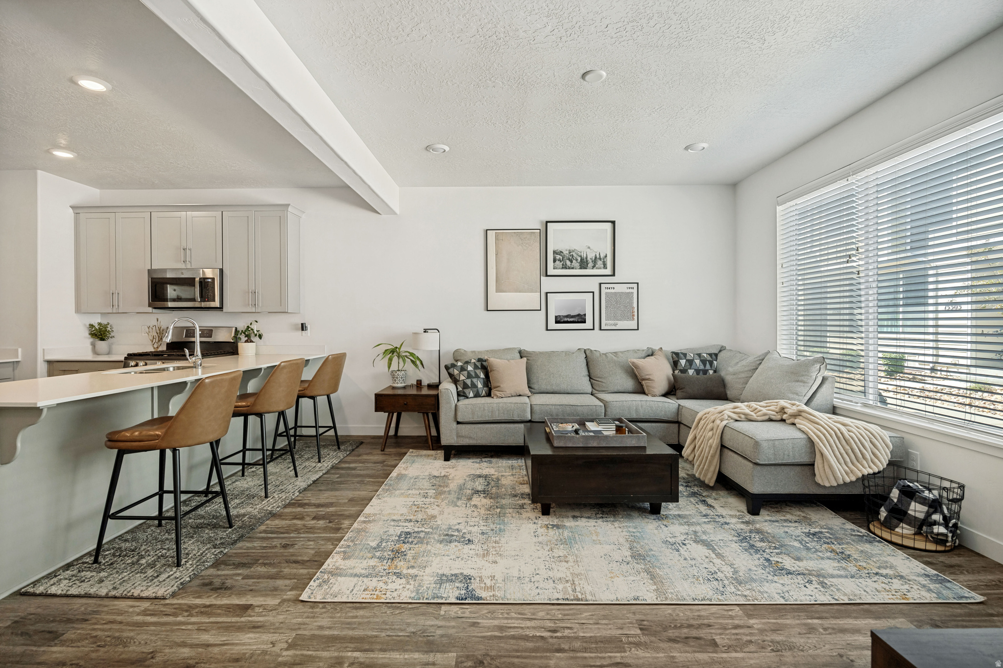 Located in Bluffdale's popular Independence at The Point community, this thoughtfully designed townhome offers an ideal combination of quality finishes, a functional layout, and exceptional amenities. The open floor plan is enhanced by 9-foot ceilings on both the main and upper levels, creating a bright and spacious feel throughout. The beautifully appointed kitchen features quartz countertops, stainless steel appliances, including a gas range, and an expansive peninsula with bar seating, creating a natural gathering space for entertaining or everyday living. Upstairs, the spacious primary suite offers a large walk-in closet, while one of the two secondary bedrooms features a large walk-in closet and beautiful mountain views. The unfinished basement provides excellent storage today while offering the opportunity to add additional living space and potential value in the future. Enjoy access to a community pool, parks, playgrounds, pickleball and basketball courts, picnic pavilions, a skate park, and miles of walking and biking trails, all within easy reach of shopping, dining, and major commuter routes.