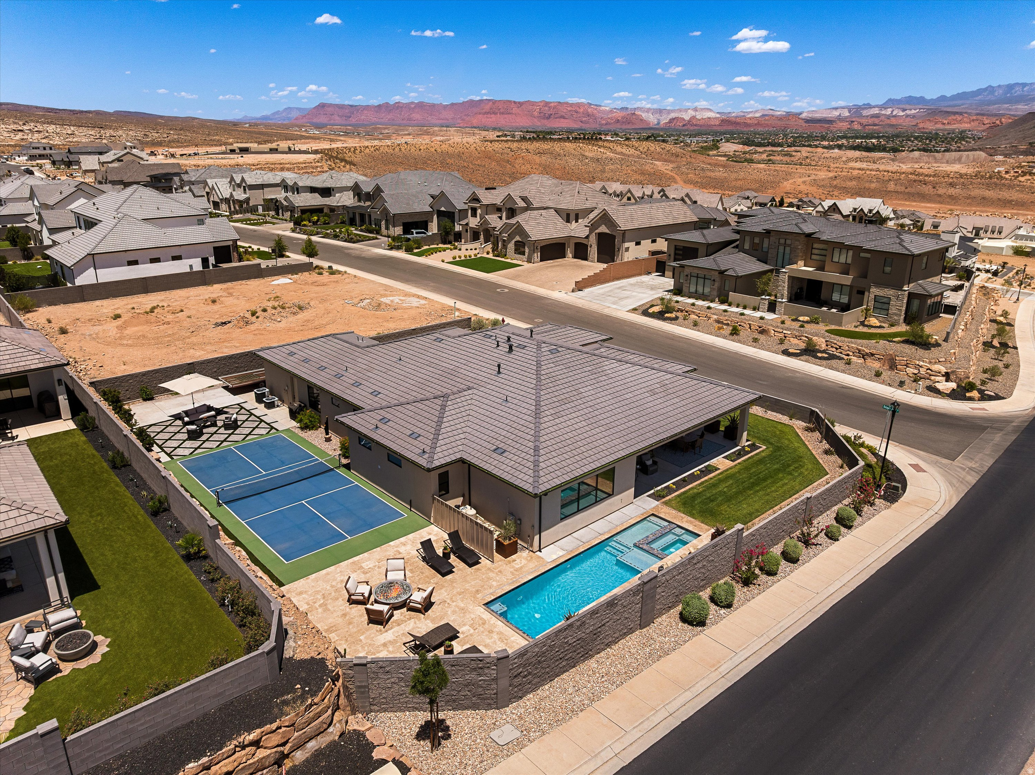 Experience Southern Utah living at its finest in this stunning single-level home, perfectly positioned next to open space for added privacy and unobstructed views. Enjoy breathtaking views of Zion National Park, Pine Valley Mountain, and the Red Cliffs from your own backyard. Designed for both entertaining and everyday living, the backyard is a true retreat featuring a shaded patio with built-in speakers, a heated saltwater pool with an automatic cover, water feature, lighted pickleball court, outdoor fire pit, and 50' RV parking. Located just moments from Moe's Valley Trail, you'll have hiking, biking, and endless outdoor adventure right outside your door. Inside, the open-concept floor plan is filled with upscale finishes, including natural quartzite countertops, stainless steel Bosch appliances, a spacious walk-in pantry complete with a dry bar, and a cozy electric fireplace. A large bi-fold door with a retractable screen seamlessly connects the indoor and outdoor living spaces, while built-in speakers in both the living room and patio create the perfect setting for entertaining. The spacious primary suite features a luxurious ensuite with a rain shower and a well-designed walk-in closet with washer and dryer hookups for added convenience. Additional highlights include an extra-deep garage that comfortably accommodates full-size trucks, an epoxy-coated garage floor, and a 220 volt outlet that can be used to charge an electric vehicle or easily routed through the wall for RV power. Smart switches for the outdoor lighting, professionally tinted windows throughout much of the home for added comfort and energy efficiency, and thoughtful upgrades complete this exceptional property. Combining luxury, functionality, and an unbeatable location, this home offers one of the best outdoor lifestyles Southern Utah has to offer.