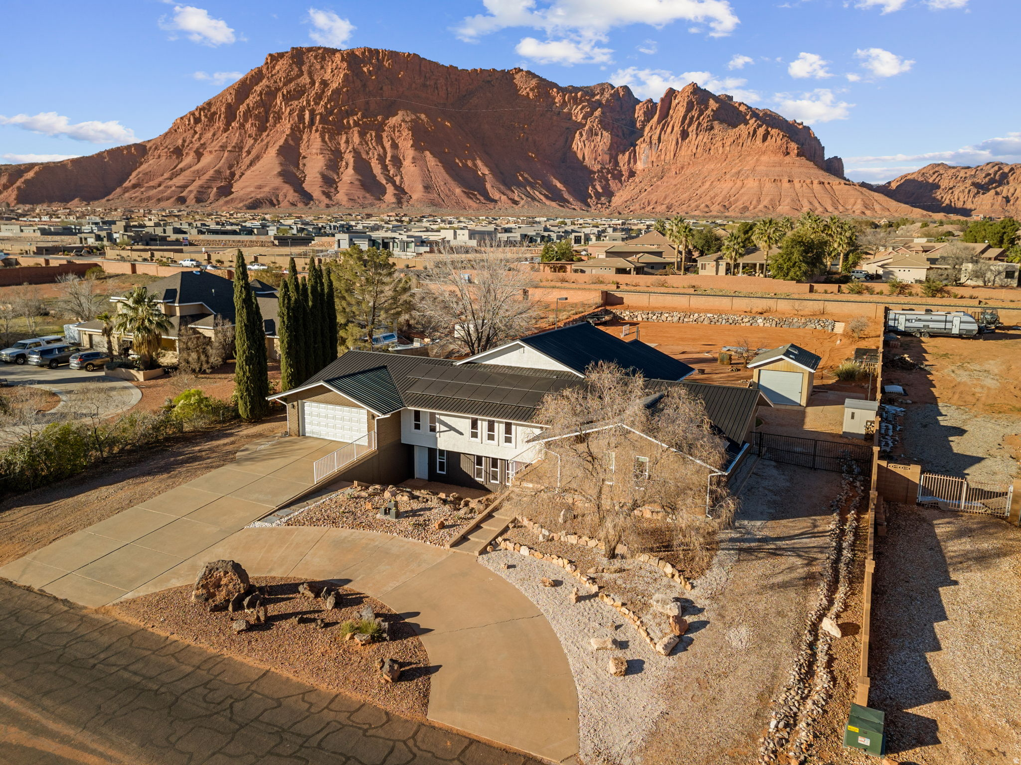 Nestled on an expansive 0.87-acre estate in the coveted Padre Canyon area, this beautifully remodeled home offers an unparalleled blend of comfort, style, and outdoor enjoyment, with 180-degree red rock views. With 6 bedrooms, 4 bathrooms, and approximately 3,249 sq. ft. of thoughtfully updated living space, this property is designed for everyday living and gracious entertaining alike. Open floor plan bathed in natural light and enhanced by fresh paint, new flooring, and updated countertops throughout. Dedicated theater room with projector, screen, and built-in speakers. A generous bonus room and ample storage areas offer flexibility for hobbies, an office, or play. Recent upgrades include two new HVAC systems, a brand-new roof, and solar panels. The sprawling grounds feature mature landscaping with fruit trees, a splash pad, an in-ground trampoline, a play-set, and a sports court. With horse privileges on this oversized lot, equestrian enthusiasts will find room to roam. Proximity to outdoor attractions like Snow Canyon State Park, Tuacahn Amphitheater, Black Desert Championship Golf, and Gunlock Reservoir makes this home the best of desert living. "Information deemed reliable, buyer to verify all information, including utilities, rental restrictions, and HOA information if applicable."