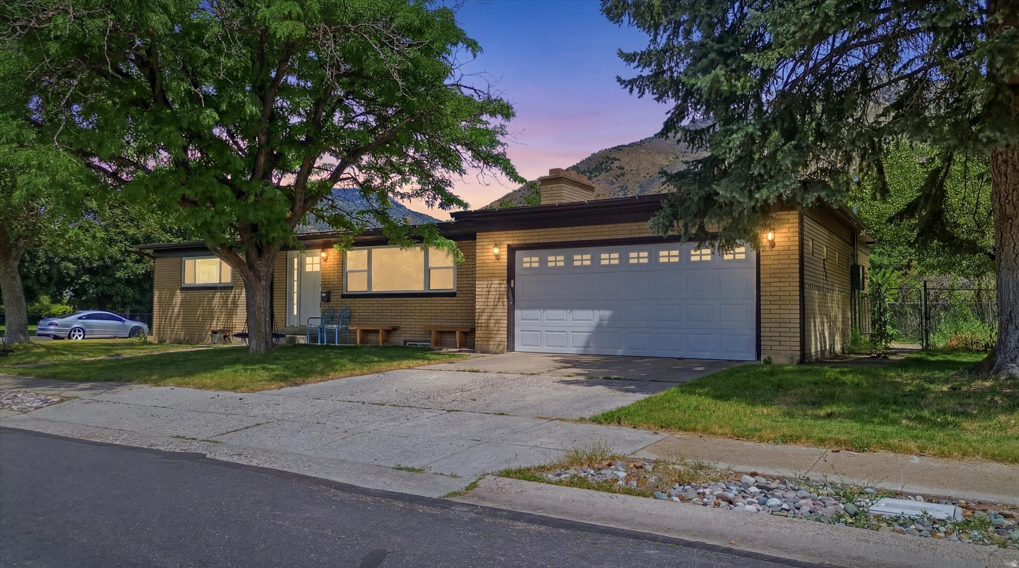 Located just east of USU in the highly sought-after Hillcrest neighborhood, this spacious home offers an unbeatable combination of comfort, convenience, and privacy. Featuring two oversized family rooms, each with its own cozy fireplace, there's plenty of space for gathering, entertaining, or simply relaxing.  The home includes four generously sized bedrooms, two bathrooms, and a deep two-car garage with added electrical service for convenient electric vehicle charging. Step outside to enjoy the covered patio-perfect for summer BBQs, outdoor dining, and entertaining guests. The fully fenced backyard is lined with mature greenery, creating a peaceful and private retreat.  The current owners have thoughtfully updated the home by replacing the front door, all upstairs windows, the garage door, and adding electrical upgrades for an electric vehicle.  Previous owners had updated roof, soffit and fascia, and HVAC.  Conveniently located near USU, schools, parks, and shopping, this is a wonderful opportunity to own a home in one of the area's most desirable neighborhoods.
