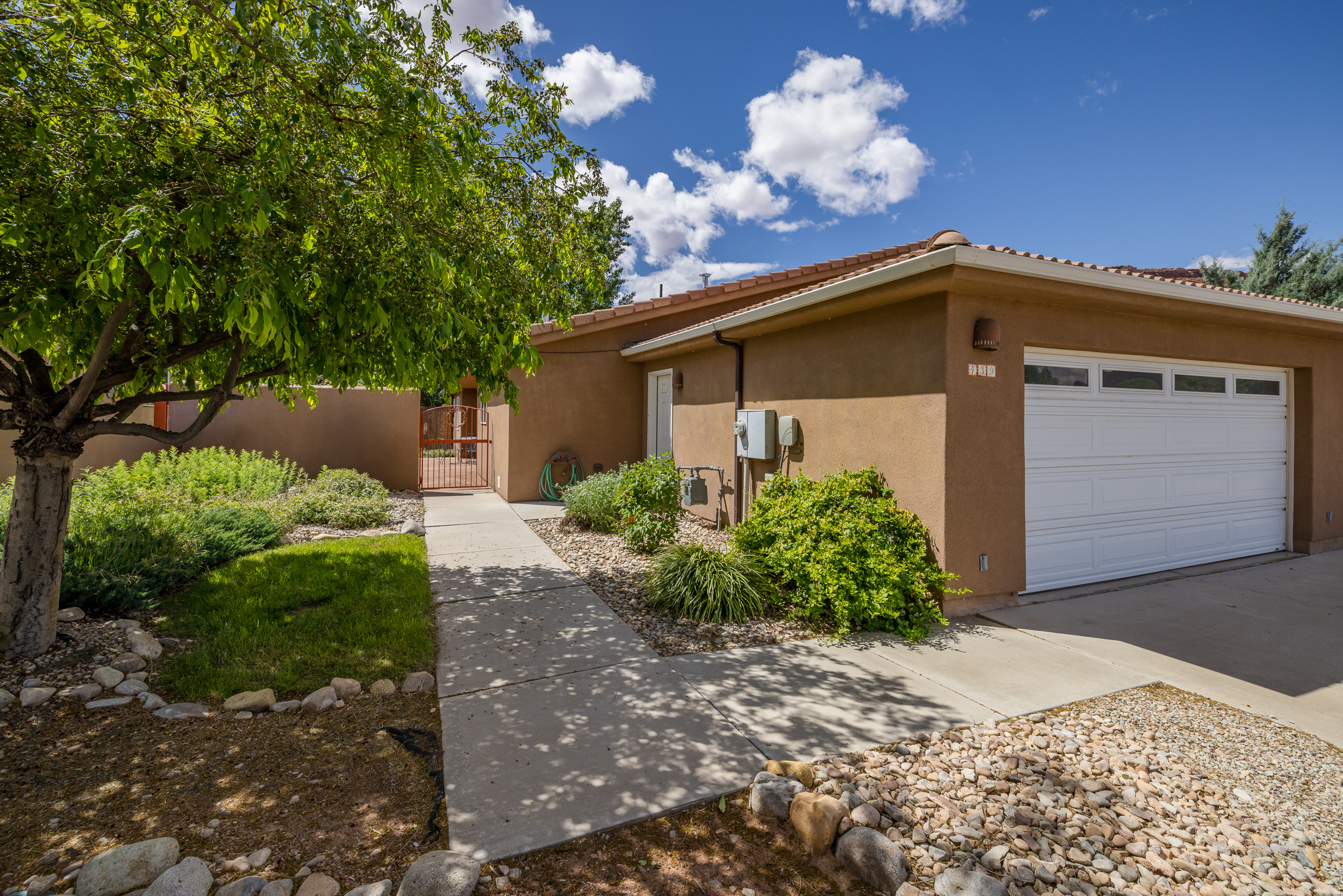 PRIVATE OUTDOOR LIVING- Welcome to this inviting 3-bedroom, 3-bathroom home offering 1,791 square feet of comfortable living on a .12-acre lot in the desirable Cottonwoods at Williams Way community. Enter through the front gate to a charming stone patio that immediately sets a peaceful and private tone. Inside, a spacious living room provides plenty of room to gather and flows naturally into the kitchen and dining areas, creating a layout that feels open while still maintaining defined spaces. The kitchen features black appliances, abundant oak cabinetry, and a breakfast bar with seating for two. Just beyond, the dining area offers generous space for both everyday meals and entertaining, with sliding glass doors that open to the patio, making indoor and outdoor living feel seamless. The primary suite is generously sized and thoughtfully placed, offering a private retreat with an en-suite bathroom that features a large jetted tub. A door to the back patio creates a seamless connection to the outdoor living space, perfect for enjoying quiet mornings or unwinding in the evening. The additional bedrooms are thoughtfully arranged for flexibility. One guest bedroom offers direct access to the back patio through an exterior door, while the second bedroom is privately positioned nearby. These two rooms share a full bathroom, making the layout ideal for guests or family. A third bathroom is conveniently located off the main living area near a dedicated laundry room. The backyard offers a quiet retreat with mature landscaping, established greenery, a hot tub pad, and beautiful stonework throughout. A stone pathway leads to a private outdoor shower, while multiple patio areas provide space for dining, relaxing, or gathering with friends and family, all set against red rock views. With three bedrooms and three bathrooms, the home offers flexibility for a variety of living arrangements. With short term rental zoning, this property presents strong potential for a primary residence, second home, or investment opportunity.