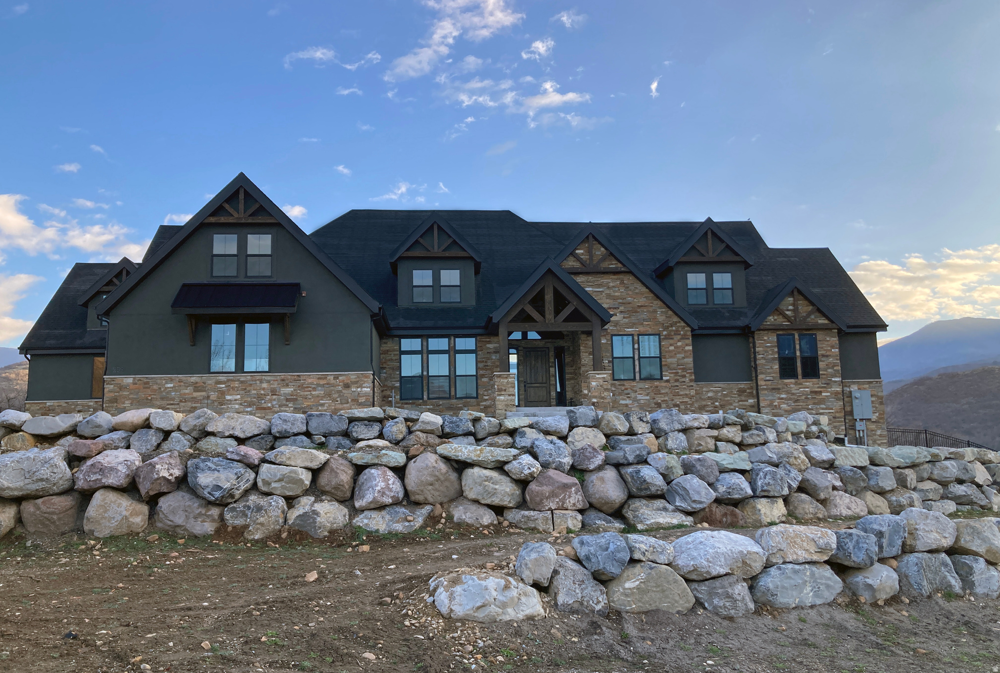 Rustic charm meets refined luxury in this custom-built mountain retreat with breathtaking views of Hobble Creek Canyon and Provo Peak. Experience mountain living with vaulted ceilings, timber posts and beams and expansive windows that connect the indoors to the surrounding landscape. The vaulted front entry opens up into the Great Room with vaulted tongue and groove ceilings, timber beams, grand chandelier, custom rock fireplace and floor to ceiling windows. The beautiful gourmet kitchen is perfect for hosting large gatherings with an oversized island, dual ovens and stovetops, built-in refrigerator/freezer, a walk-in pantry, ample cabinet space to keep everything organized. The views from the kitchen and dining area are stunning. The primary bedroom suite boasts vaulted tongue and groove ceilings, timber beams, rustic chandelier, cozy rock fireplace, two-person soak tub, spacious shower and large walk-in closet. The four upstairs bedrooms, one w/ a spiral staircase, have walk-in closets and vaulted ceilings with incredible views. A custom commercial grade playground slide joins the main level to the basement, in addition to the timber framed stairs. The high ceilings and oversized windows in the basement create a bright open feel. Downstairs bedrooms have walk-in closets, large windows, and custom window wells. An exercise room, large workshop or craft room w/ garage stair access, and cold storage, provide space for multiple uses including a conversion into a separate apartment if desired. The fully finished four car garage has plenty of room for toys, boats, ATVs, etc. The backyard is your oasis to entertain and relax with mountain views from the pickleball court, backyard patios and sidewalks, firepit area, grass lawn and heated swimming pool w/ electric cover. Boulder retaining walls, fencing, and inground sprinkler system are all in place, ready for your personalized finishing touches. Come see what luxury mountain living looks and feels like.