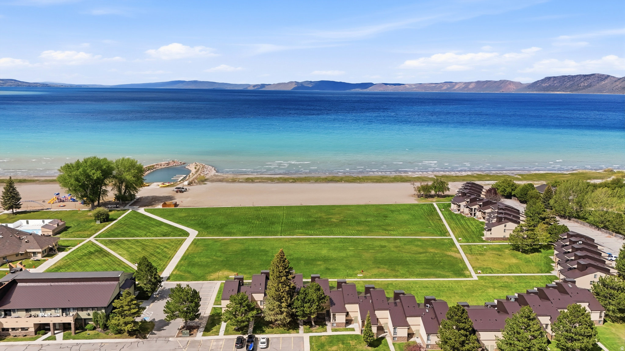 Prime Bear Lake retreat opportunity with direct walkout access to the grass, beach, lake views, and neighboring units also available for a rare multi-unit ownership setup. This fully furnished main-level combination features 2 bedrooms, 2 full bathrooms, spacious living area, full kitchen, patio, and beautiful mountain and lake views. Recently updated with a brand-new metal roof and currently participating in the established rental pool with strong summer bookings already in place. Buyer to honor existing rental pool participation through the current rental term ending September 7, 2026. An outstanding opportunity for personal use, investment potential, or for multiple families looking to secure adjoining units together in one of Garden City's most desirable resort locations. ***Square footage figures are provided as a courtesy estimate only and were obtained from county records. Buyer is advised to obtain an independent measurement.