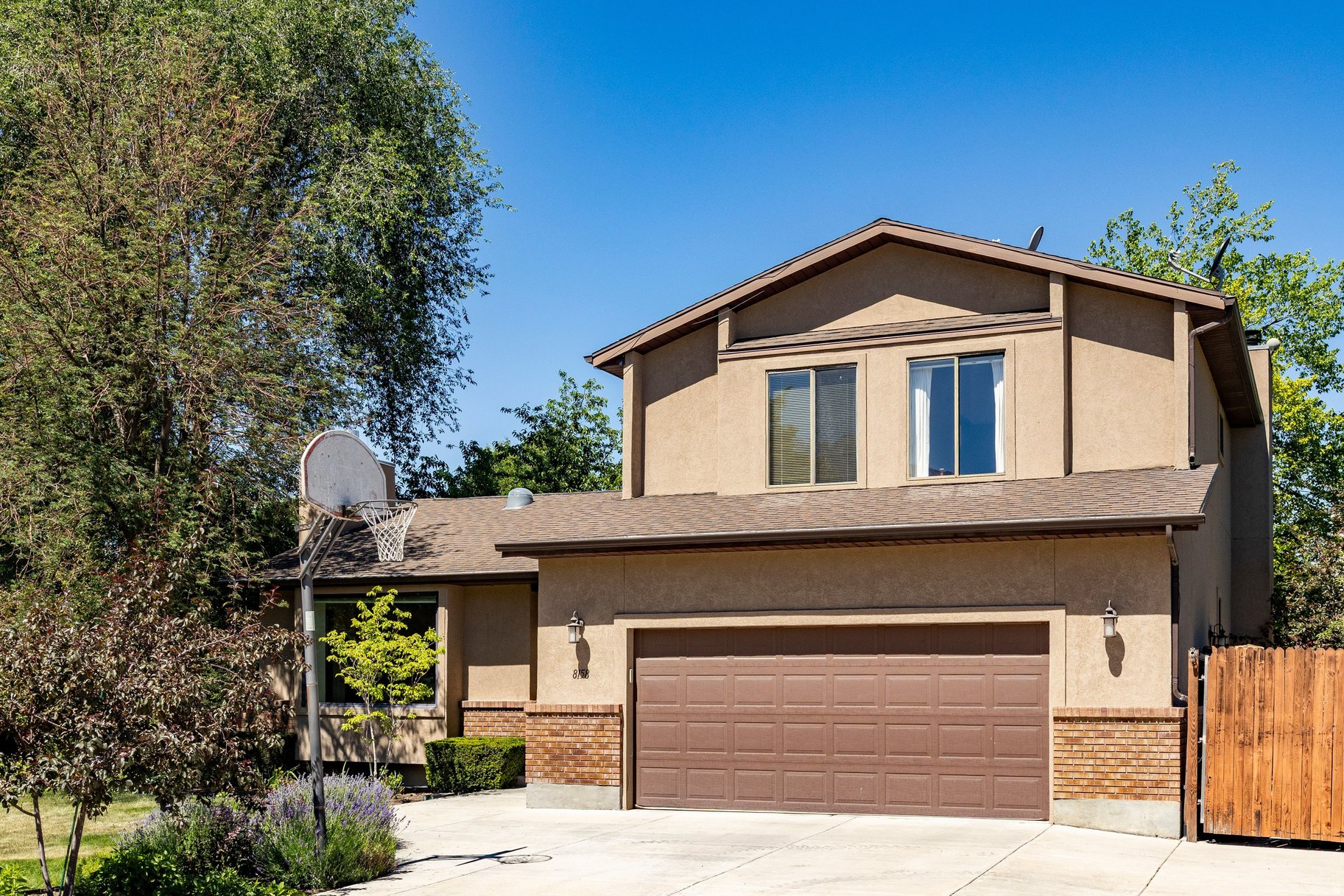 Welcome to this immaculate 6-bedroom, 3-bath home nestled in the highly desirable Oakwood Estates neighborhood of Sandy, just minutes from Willow Creek Country Club and Flat Iron Mesa Park. Thoughtfully maintained, this two-story home offers the perfect blend of classic charm and modern updates. Step inside to find rich natural wood floors and stunning oak staircase that sets the tone throughout. The spacious great room flows into a formal dining area, while the kitchen and generous family room with wet bar make entertaining effortless. Vaulted ceilings and skylights add an airy, elegant feel, and the gas log fireplace brings warmth and character to the main level. The primary suite features a private bath, and all six bedrooms offer generous proportions, ideal for large families or those needing a dedicated office or hobby space. The fully finished basement adds an even more flexible living area. Outside, enjoy a freshly landscaped yard complete with mature trees, full auto sprinklers, and a large private deck with a hot tub, all framed by breathtaking mountain views. The fully fenced, secluded yard provides privacy rarely found at this price point. A 2-car attached garage with extra height and width rounds out this exceptional offering.