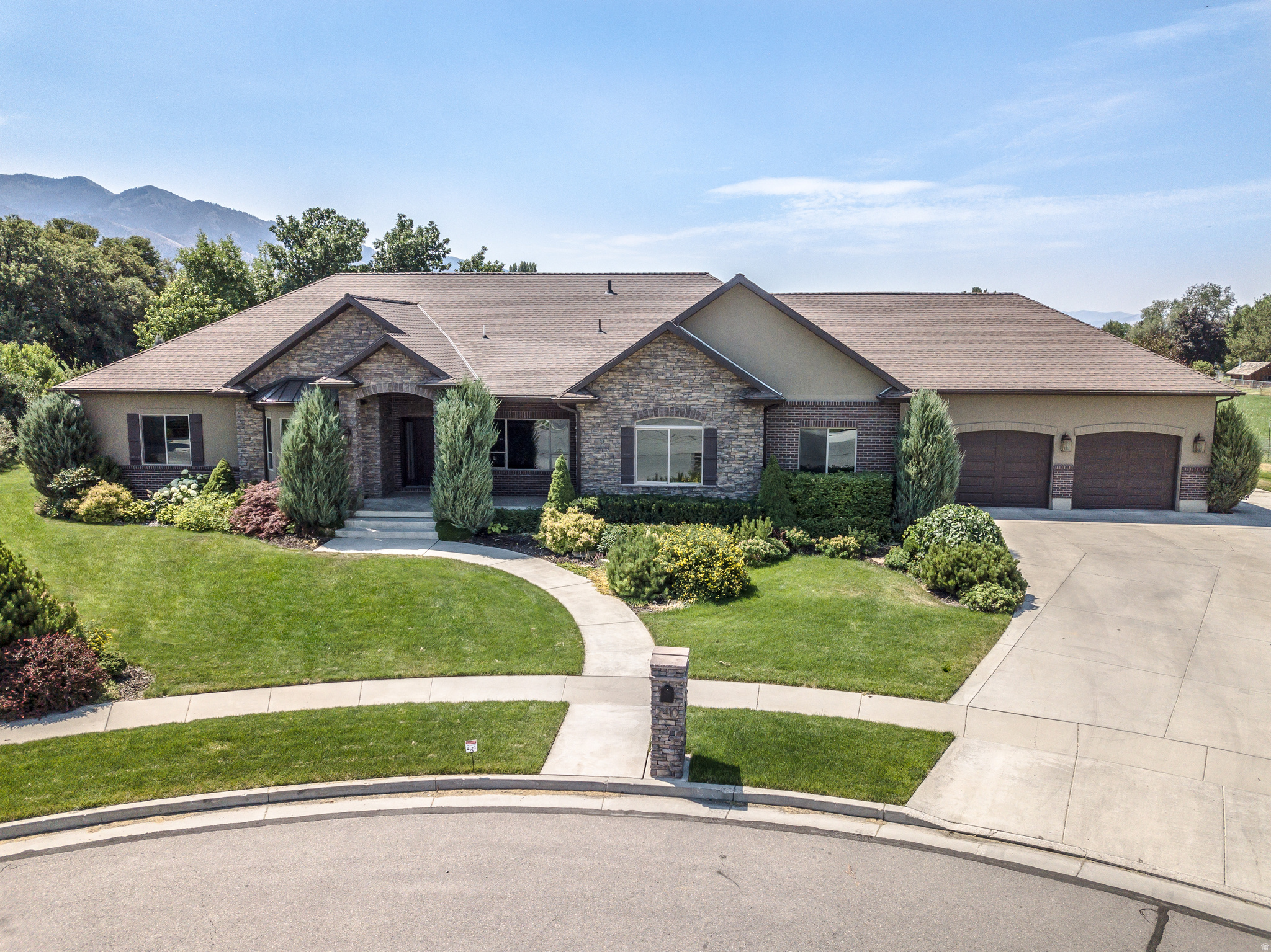 SPECTACULAR NORTH LOGAN HOME built in 2014 with 6,402 sq ft, 6 bedrooms, 5 bathrooms, radiant in-floor heat, open floor plan, large great room with vaulted ceilings, stone fireplace, custom built-in cabinetry & huge windows providing tons of natural light, beautiful chefs kitchen w/ massive island, extensive custom cabinetry, granite countertops, commercial-style refrigerator, stainless steel appliances and double ovens, spacious primary suite with large walk-in shower, double sinks and extensive cabinetry, huge family room and second kitchen / wet bar in basement, multiple gathering areas, abundant storage, covered patio, incredible swimming pool & spa, mature landscaping, beautiful mountain and valley views, NO BACKYARD NEIGHBORS, and an AMAZING 1,960 SQ FT GARAGE with plenty of room for vehicles, toys, workshop space and storage, and much more!