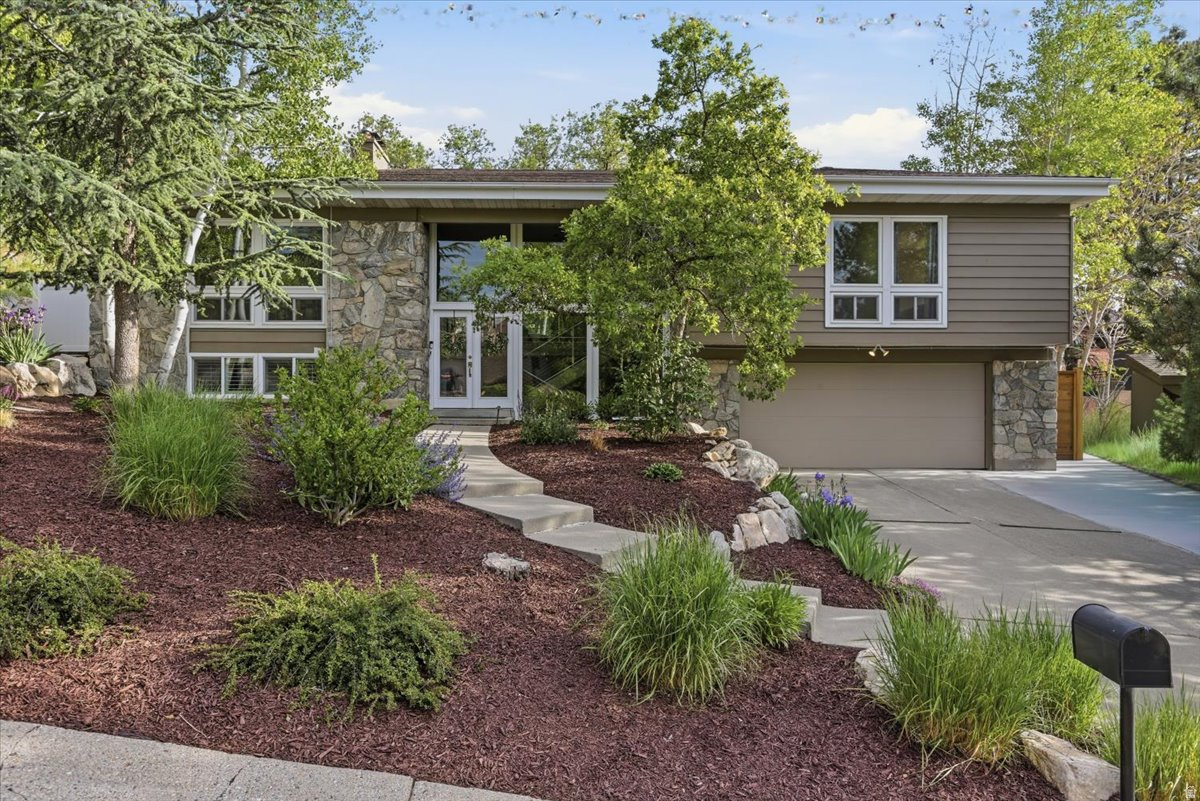 Multiple Offers Received. Highest and Best Offer deadline is 10:00 am on Sunday May 31st with a response time of Monday June 1st at 10:am. Perched on a pristine lot above the Salt Lake Valley, this exquisite home welcomes you with warmth, comfort, and timeless style. From the moment you arrive, the impeccably manicured landscaping reflects true pride of ownership. Step inside and you'll immediately be embraced by abundant natural light pouring in from every direction, creating an inviting atmosphere throughout the home. The thoughtfully designed main living area offers an open, seamless flow from room to room-perfect for both everyday living and effortless entertaining. The well appointed kitchen features expansive windows that frame stunning scenery to enjoy while you prepare delicious meals. The spacious dining area easily accommodates gatherings of any size. Just beyond, the gorgeous living room centers around a fantastic fireplace and showcases exceptionally large windows to the backyard.  Entertaining continues outdoors on the expansive patio, complete with multiple seating areas, accent lighting, and charming caf lights that create a magical ambiance on warm summer nights. Whether hosting unforgettable parties or enjoying a quiet evening alone, this outdoor retreat delivers the ultimate private oasis-especially when relaxing in the hot tub after a long day. The main floor includes three spacious bedrooms, including a serene primary suite while the other bedrooms offer flexibility for guest rooms, family living, or a quiet home office. Downstairs, a second cozy gathering space with another fireplace invites you to settle in for movie nights and binge-worthy marathons. Additional highlights include exceptional garage storage with built-in cabinets perfectly designed for skis, outdoor gear, and more. Elegant yet comfortable, sophisticated yet inviting, this remarkable home blends luxury entertaining with the cozy feel of a private retreat above the valley.