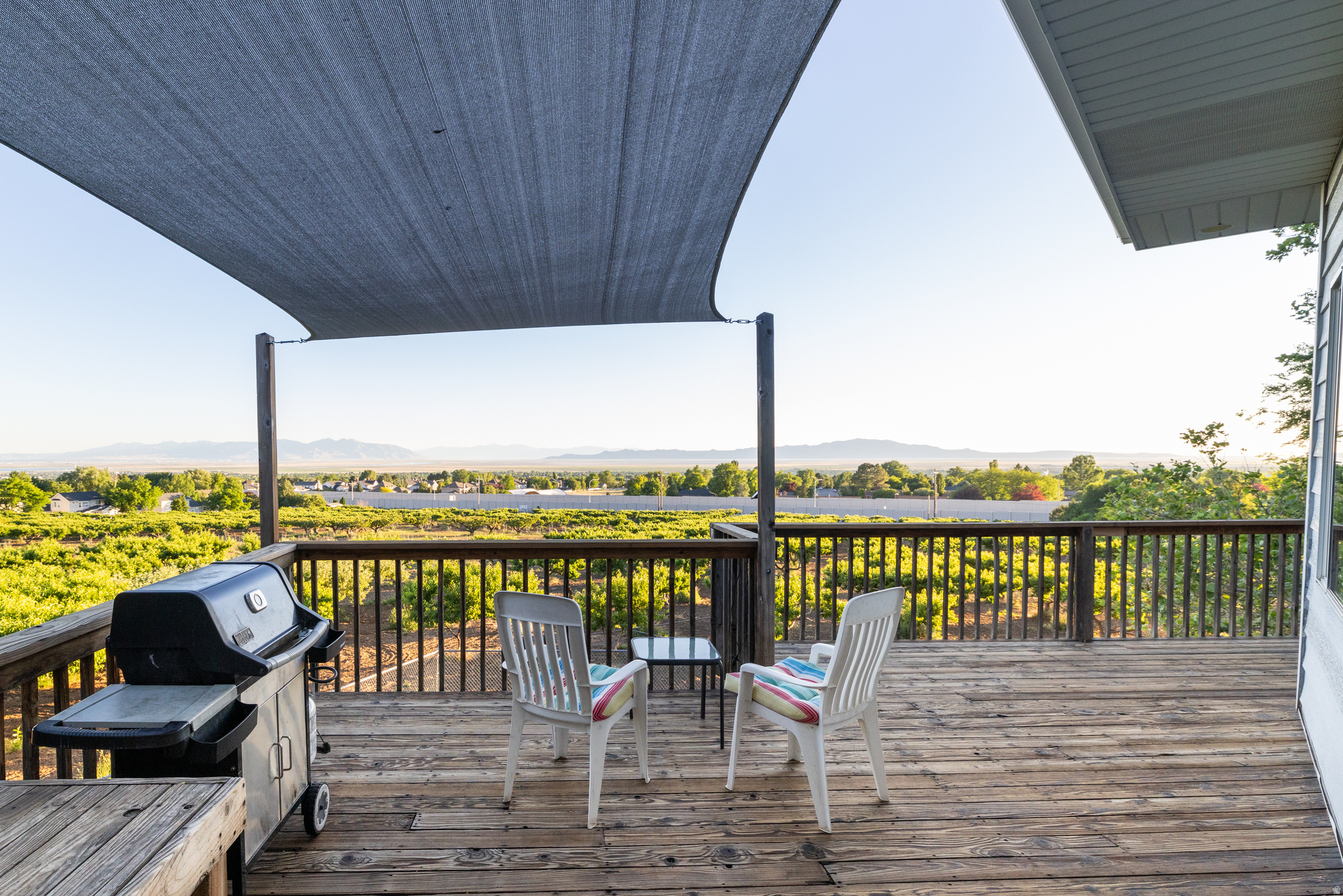 Perched in a spectacular location with breathtaking panoramic views, this beautiful 4-bedroom, 3-bathroom home offers an exceptional combination of comfort, privacy, and outdoor living. Enjoy unobstructed vistas of the Wasatch Mountains, the Great Salt Lake, and Antelope Island, with stunning sunsets that can be enjoyed year-round from multiple outdoor spaces.  The fully fenced private backyard is surrounded by a picturesque peach orchard and features three separate outdoor sitting areas designed for relaxation and entertaining. A spacious 400-square-foot deck, lower patio, and covered veranda provide the perfect setting to take in the incredible scenery and peaceful surroundings.  Inside, the home offers a fully finished basement, with the exception of a dedicated workshop area featuring a durable concrete floor. The workshop is a craftsman's dream, complete with ample electrical service, including 240-volt outlets, making it ideal for woodworking, hobbies, or projects of any scale.  Outdoor enthusiasts will appreciate being just minutes from the Bonneville Shoreline Trail, offering miles of opportunities for walking, running, hiking, and biking. Convenient access to the newly improved Mountain Road Highway provides an easy connection to I-15 and a quick commute to Salt Lake City.  If you've been searching for a home that combines incredible views, outdoor enjoyment, functional workspace, and a prime location, this property is a must-see.