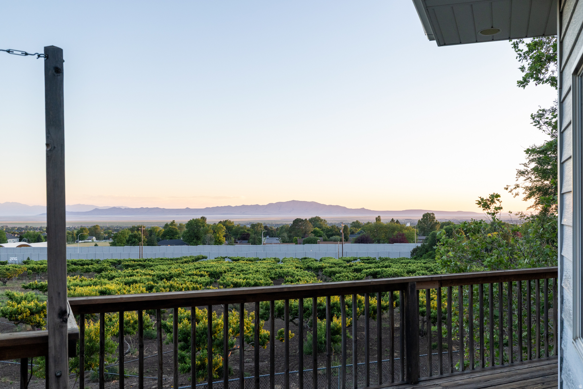 Perched in a spectacular location with breathtaking panoramic views, this beautiful 4-bedroom, 3-bathroom home offers an exceptional combination of comfort, privacy, and outdoor living. Enjoy unobstructed vistas of the Wasatch Mountains, the Great Salt Lake, and Antelope Island, with stunning sunsets that can be enjoyed year-round from multiple outdoor spaces.  The fully fenced private backyard is surrounded by a picturesque peach orchard and features three separate outdoor sitting areas designed for relaxation and entertaining. A spacious 400-square-foot deck, lower patio, and covered veranda provide the perfect setting to take in the incredible scenery and peaceful surroundings.  Inside, the home offers a fully finished basement, with the exception of a dedicated workshop area featuring a durable concrete floor. The workshop is a craftsman's dream, complete with ample electrical service, including 240-volt outlets, making it ideal for woodworking, hobbies, or projects of any scale.  Outdoor enthusiasts will appreciate being just minutes from the Bonneville Shoreline Trail, offering miles of opportunities for walking, running, hiking, and biking. Convenient access to the newly improved Mountain Road Highway provides an easy connection to I-15 and a quick commute to Salt Lake City.  If you've been searching for a home that combines incredible views, outdoor enjoyment, functional workspace, and a prime location, this property is a must-see.