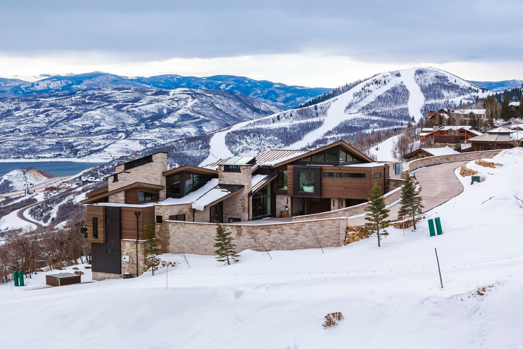 Nestled in the prestigious Deer Crest Estates of Deer Valley, this brand-new masterpiece, designed by world-renowned architect Michael Upwall and crafted by Jackson LeRoy, offers unparalleled luxury and craftsmanship. Located on a private 0.74-acre lot at the end of a quiet cul-de-sac, this home boasts unobstructed views of the Jordanelle Reservoir and offers direct Ski In/Ski Out access.  Spanning 11,419 square feet, the home features 6 en-suite bedrooms, including an extraordinary bunk room and 3 master suites, each a private sanctuary. The design blends contemporary elegance with luxurious living spaces, ensuring comfort throughout. High-end amenities include a luxurious aprs-ski lounge, a custom glass elevator, a theater room, and a gym room, while radiant heat flows throughout, including the heated driveway, providing warmth year-round.  The Grand Master suite, perched on the top floor, offers panoramic views of the Jordanelle Reservoir from its private deck-perfect for serene mornings or breathtaking sunsets.  Designed for grand entertaining, the home features multiple outdoor living areas that seamlessly blend with the indoor spaces, making it perfect for hosting family and friends or enjoying intimate moments. With its blend of luxury, sophistication, and Ski In/Ski Out access, this home represents the ultimate in Deer Valley living.