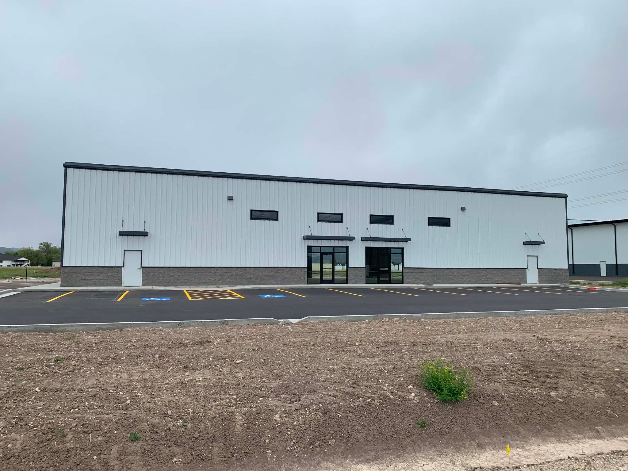 Discover an exceptional opportunity in Elwood Crossing with this brand-new, duplex-style industrial building. Ideally situated in a rapidly growing area of Northern Utah, this property boasts outstanding freeway access and high visibility at I-15/I-84 Exit 376 - perfect for users seeking maximum exposure and convenience. Offering a flexible footprint from 3,600 to 7,200 square feet, this space is well-suited for owner/user, investment, or a combination. Key features include four 14-foot overhead doors for easy loading and unloading, high ceilings, ample on-site parking, and a secure, fenced storage yard to keep your assets safe. Commercial zoning allows for a variety of industrial, commercial, or retail uses. The owner is open to both selling or leasing the property, making this a rare opportunity to secure a space tailored to your business goals.
