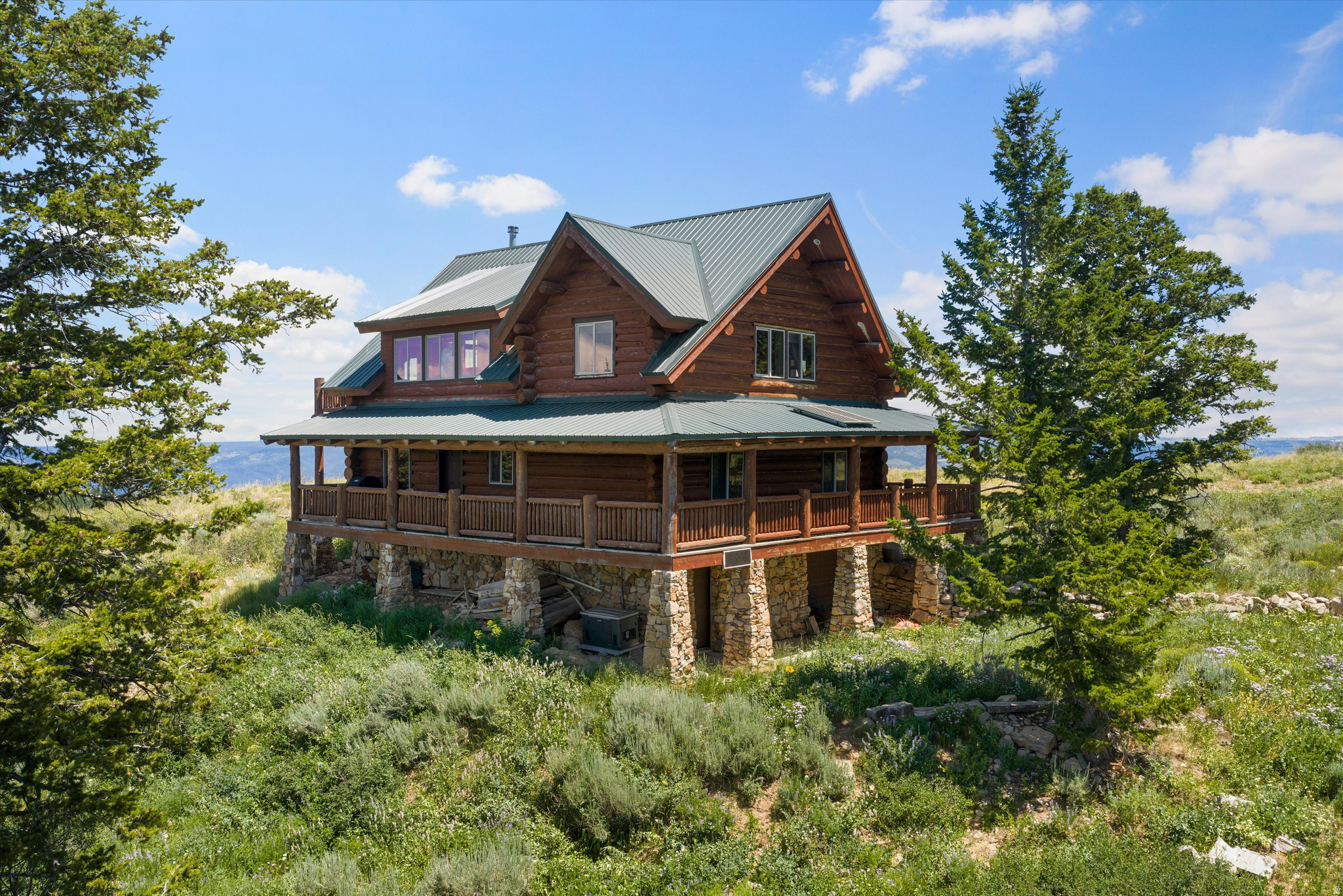 Sportsman's Paradise! This is a rare opportunity to own a turn-key off-grid mountain estate on 40 wooded acres at the top of Scare Canyon. As an owner, you'll enjoy exclusive gated access to nearly 2,500 private acres for year-round recreation, making this the ultimate four-season retreat for hunters and outdoor enthusiasts. Surrounded by breathtaking valley and mountain views, this sturdy two-story log cabin combines rustic charm with modern comfort. Inside, warm wood interiors, vaulted ceilings, expansive windows, and a cozy wood-burning stove create an inviting atmosphere. The main level features a spacious living room, primary bedroom, full bath, and a large kitchen and dining area centered around a massive oak and slate dining table. Upstairs, a bright open loft overlooks the great room and offers additional sleeping space, while the adjacent bunk room comfortably accommodates up to 12 guests. The fully finished basement is designed for entertaining with a living area, authentic turn-of-the-century bar, pool table, foosball table, game room, entertainment space, and an additional bathroom. Outside, the wrap-around covered deck is the perfect place to barbecue, gather with family and friends, watch wildlife, or simply enjoy the peaceful mountain setting in every season. The garage provides ample storage for ATVs and houses the battery bank, while a generator and 1,000-gallon propane tank ensure reliable year-round off-grid living. Sold fully furnished, this one-of-a-kind mountain retreat is move-in ready and waiting for your next adventure.