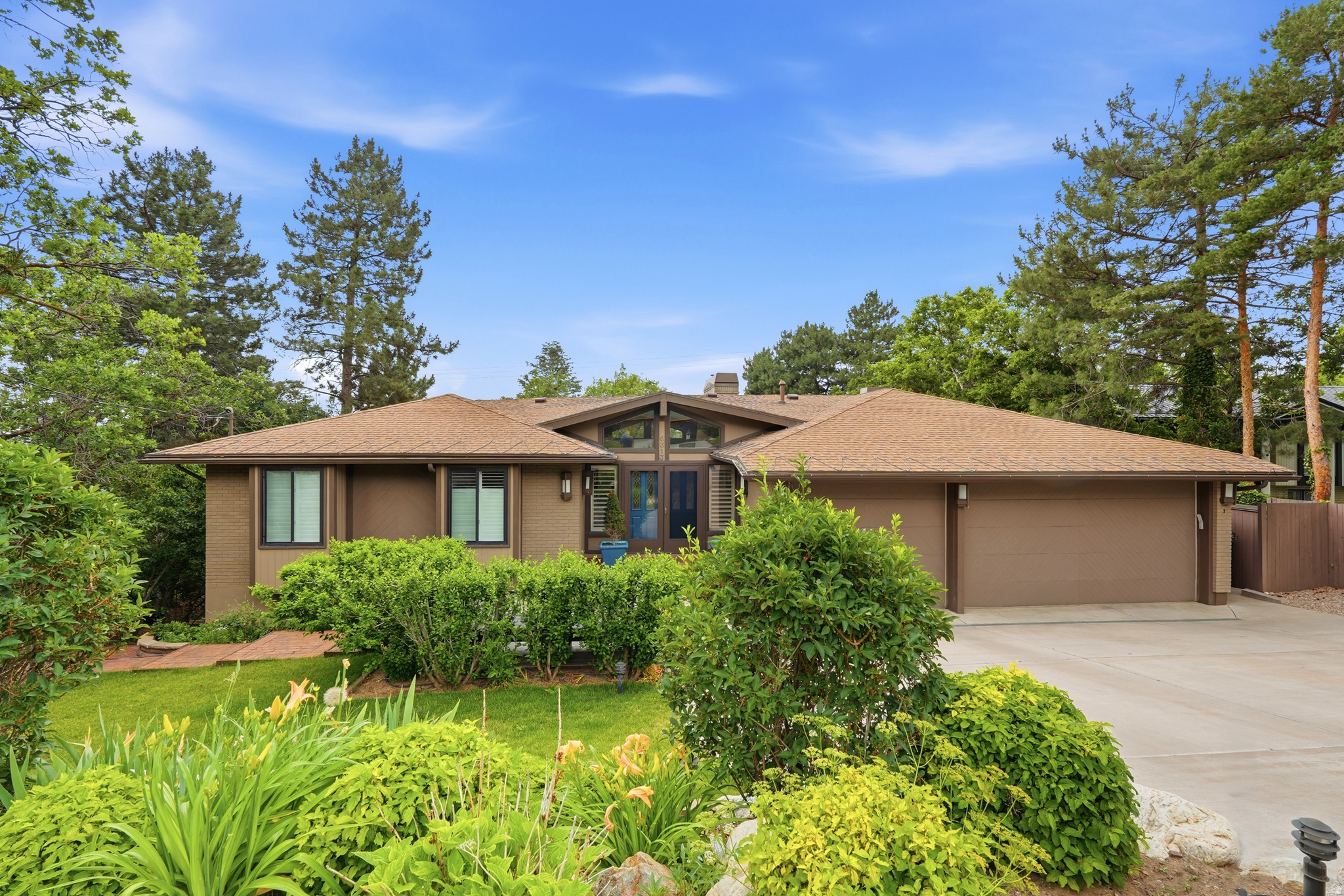 Welcome to 6313 Bybee Dr! Located in a highly desirable Ogden neighborhood, this beautifully maintained 4 bedroom, 3 bathroom home offers privacy, views, and well-designed living spaces. Set on a secluded lot with a cozy, established yard, the property features a spacious 3-car garage and a custom chef's kitchen that serves as the heart of the home. The kitchen is designed for both everyday living and entertaining, featuring two dishwashers, two cooktops, two ovens, two pantries, a large island, high-end appliances, and a range hood, along with a generous dining area and direct balcony access. All four refrigerators are included with the house. Built-in sound speakers enhance the kitchen and family room area, with additional speakers installed on the deck for seamless indoor-outdoor entertaining. Inside, updated hardwood flooring, upgraded windows, and abundant natural light create a comfortable and inviting atmosphere. The main level includes two bedrooms and two full bathrooms, a spacious primary suite with a walk-in closet, cozy sunroom/sitting area and direct access to the incredible deck. The primary bath features a large standalone shower, separate soaking tub, and double vanity. The additional upper bedroom includes a built-in dresser that will remain. A see-through wood-burning fireplace adds character to the main living space, while custom shades enhance comfort throughout. The fully finished basement provides flexible additional living space with two oversized bedrooms, a bathroom with double vanity and  shower, kitchenette, laundry and a dedicated food storage room. The theater area includes surround sound, soundproofing, projector, and screen (projector requires a new bulb). A spacious private office with built-in shelving overlooks the yard, and an additional craft room/den adds versatility. Two gas fireplaces add warmth to the lower level. Two 50-gallon water heaters, separate furnaces for each level, and additional heat sources in each bathroom provide year-round comfort. The 3-car garage features epoxy floors, built-in lockers, attic storage, a warm-water hose bib, a built-in Viking refrigerator, an additional refrigerator that will remain, and an additional shed/storage area just outside the garage. In the backyard there are two large sheds with electric power. Outdoor living is private and functional, a fenced yard featuring mature landscaping, grass areas, a play gym, multiple balconies and deck spaces, and a reinforced deck designed to support a hot tub. The property also includes a heated driveway, roof heat tape, auto sprinklers, and additional parking. This home is truly one of a kind: schedule your private showing today!