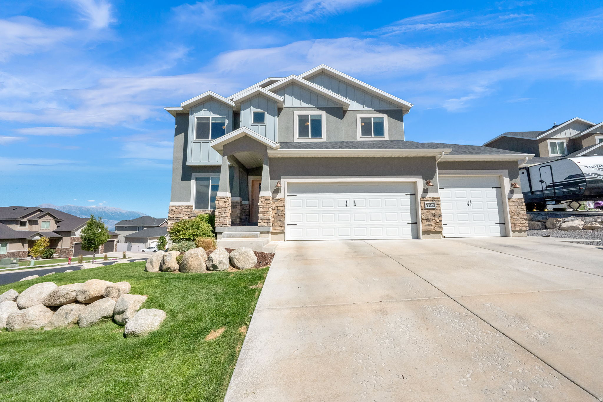 Welcome to a home that truly stands out! Enjoy breathtaking, unobstructed views from this beautifully finished property featuring a walkout basement and six spacious bedrooms. The thoughtfully designed interior showcases timeless white shaker cabinetry, granite countertops, custom board and batten and shiplap accent walls, and a cozy gas fireplace. Outside, you'll find a three-car garage with built-in shelving for extra storage, plus dedicated RV parking. This home offers the perfect combination of style, space, functionality, and incredible views.
