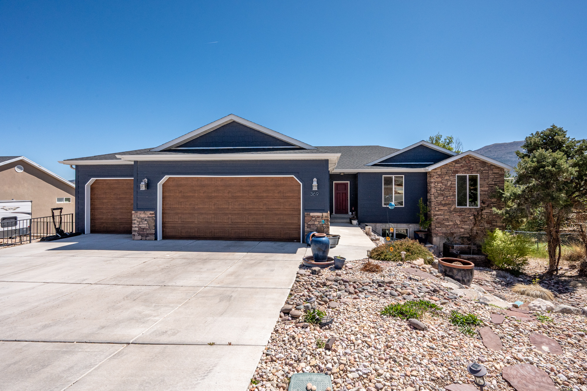 Beautifully built home with stunning valley/mountain views. This spacious open floor plan features large windows that fill the living area with natural light, vaulted ceilings, and quality finishes throughout. The kitchen offers ample cabinetry, a large island, and great flow for entertaining. Enjoy a spacious primary suite, large bedrooms, and a functional layout for everyday living. The full walk-out basement adds flexibility with a full kitchen, its own laundry, and space for guests or multi-generational living. It also comes with the full RV hookups with sewer dump and 50 amp plug. Step outside to low-maintenance landscaping and a peaceful setting, perfect for relaxing or taking in the views. The elevated lot captures valley and mountain views. Plenty of garage space and room to grow complete this well-built home. And some additional bonuses are the playhouse/artist retreat/creative space out back, the updated siding on the playhouse, the under-stairs "Harry Potter" closet.