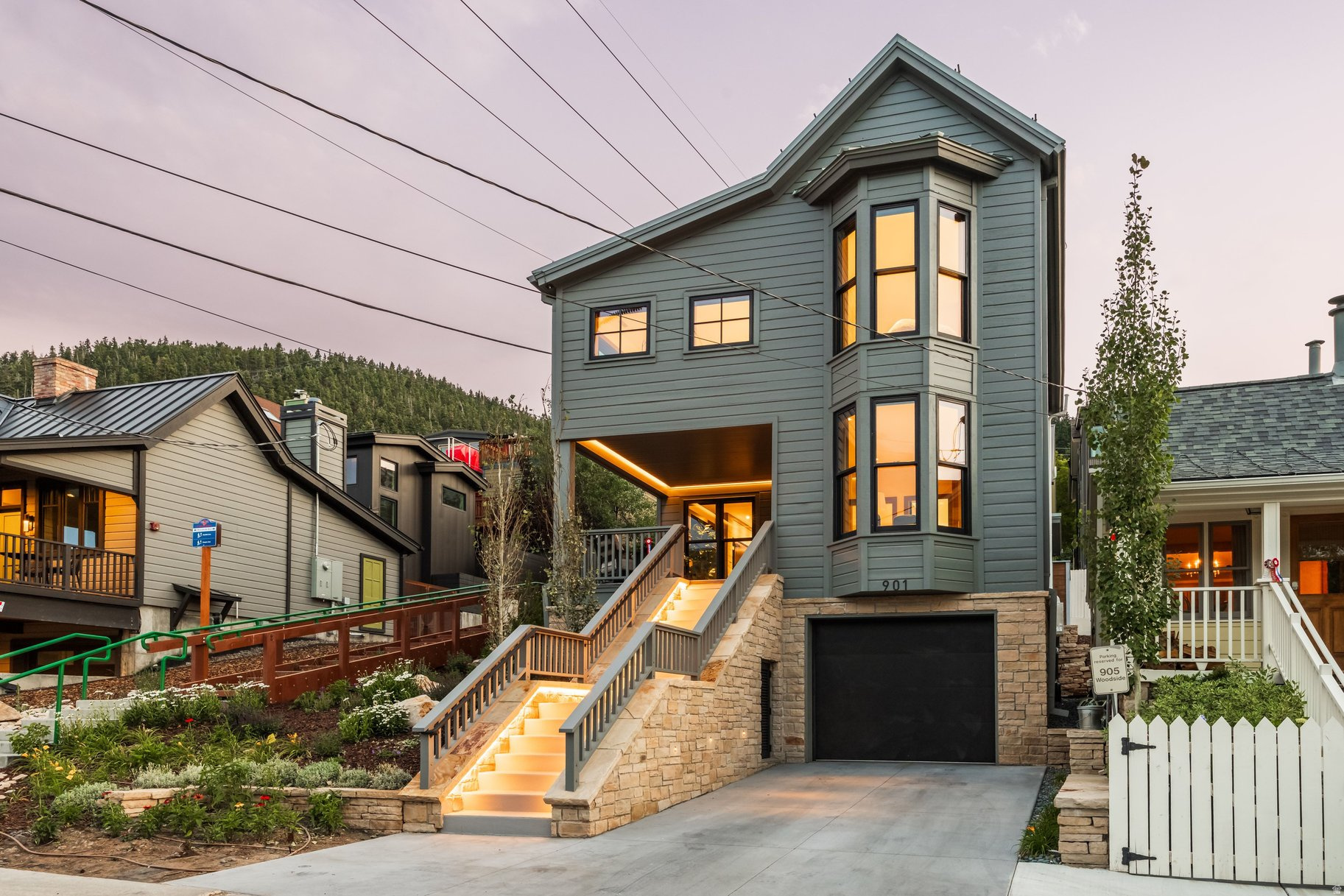 Reimagined and rebuilt with historic soul, this Old Town home sits only steps from the Town Run, with exceptional access to skiing at Park City Mountain and to Main Street's restaurants, galleries, and the Town Lift Plaza. Few properties offer this blend of ski-in convenience and walkable mountain-town charm. Inside, radiant in-floor heating and cooling with a warm board system pairs with redundant VRF heat pumps and zoned climate control, so every room feels just right, year-round. Rift-sawn white oak floors, cabinetry, and custom doors run throughout, complemented by walnut accents, open-tread staircases, and Lutron lighting and shades that set the mood at the touch of a button. The kitchen is built for gathering-walnut cabinetry, quartz countertops, a Miele appliance suite with induction range and double oven, and an island made for entertaining. The great room's gas fireplace and accordion doors open straight to the back patio, where a full snow-melt system keeps the driveway, stairs, porch, and balcony clear all season. Four ensuite bedroom suites include custom walnut closets and spa-like baths with Toto Washlets, floating vanities, and Axor and Hansgrohe fixtures. The primary suite adds its own balcony, dual vanity, and multiple shower heads. Downstairs, a media room and Walnut-clad wet bar are made for movie nights and gathering, while a mudroom, loft, and flex space add everyday flexibility. Additional highlights include a zinc metal roof with snow retention, whole-home water filtration, an HRV air filtration system, and a radiant-heated garage with epoxy flooring. Staging by Empire Crest Interiors. This is historic Old Town living, elevated.