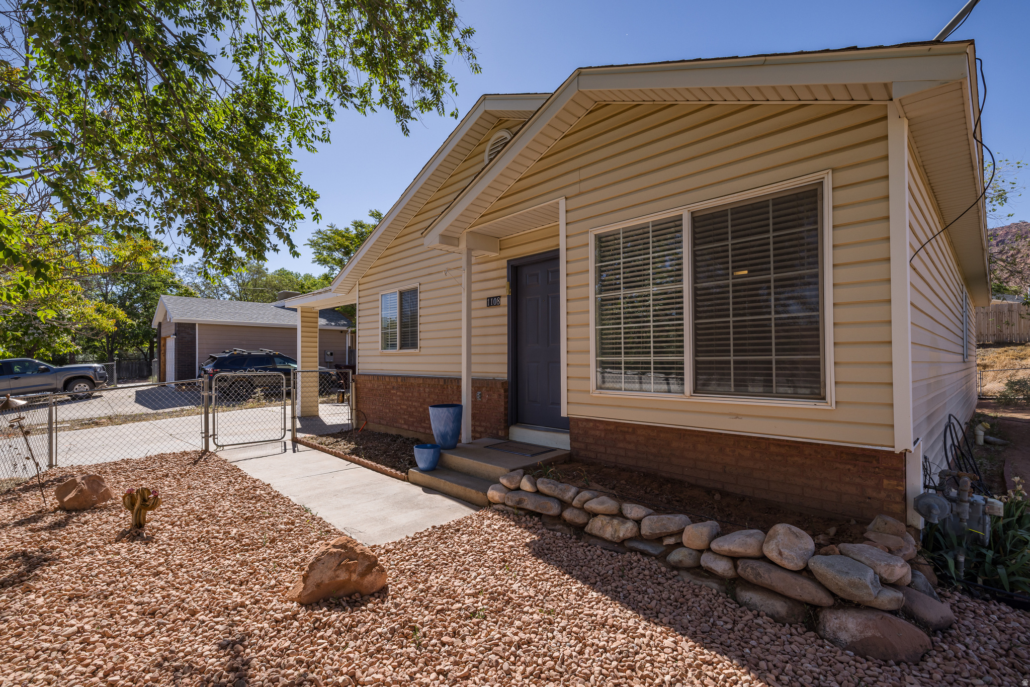 YOUR START! Spacious corner-lot ranch home offering comfortable living both inside and out. This clean and well-maintained 3-bedroom, 1-bath home features 1,170 square feet on a fully fenced .17-acre lot with covered parking, attached storage, and a backyard ready for your personal vision. Mature shade trees create a welcoming outdoor setting, while the xeriscaped front yard keeps upkeep simple and attractive. Inside, the home feels bright and refreshed with fresh white paint and durable LVP flooring throughout. A well-sized living room welcomes you upon entry, creating a comfortable gathering space with an easy flow between the living, dining, and kitchen areas. The bright corner kitchen features stainless steel appliances, abundant upper and lower cabinetry, ample counter space, and an adjoining dining area for everyday use. All three bedrooms are nicely sized, including a bonus vanity room, offering flexibility for guests, office space, or everyday living. A separate laundry room with added shelving provides additional storage and convenience. With single-level living, practical outdoor spaces, and a location close to town and nearby trails, this property offers comfort, flexibility, and a solid foundation to make your own.