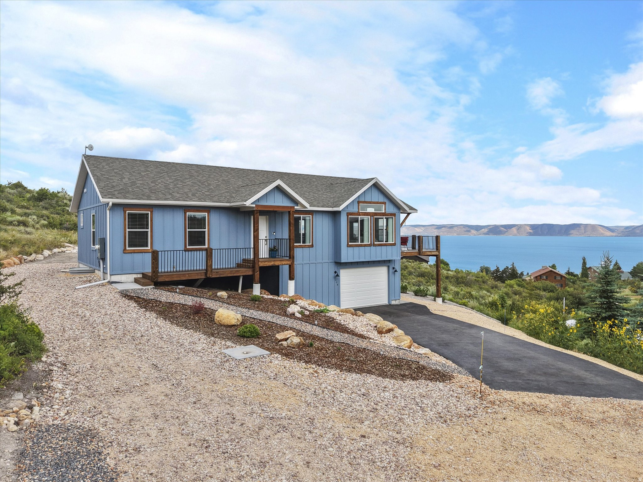 Experience elevated Bear Lake living at 608 Fremont Road in Fish Haven, Idaho - a beautifully crafted 2023 custom home designed to capture sweeping lake and mountain views from nearly every angle. Located in the desirable Bear Lake West community, this fully furnished retreat offers the perfect blend of luxury, comfort, and recreation. Inside, you'll find high-quality construction throughout with an open-concept floor plan, spacious gathering areas, and thoughtfully designed finishes that create a warm yet upscale mountain-lake atmosphere. The modern kitchen flows seamlessly into the main living area, making it ideal for entertaining family and guests after a day on the lake or trails. Step outside onto the expansive patio and deck spaces where panoramic Bear Lake views become the backdrop for morning coffee, sunset dinners, and relaxing evenings. The property also features paved parking, dedicated RV parking, and an EV hookup in the garage - providing convenience for full-time living or a turnkey vacation getaway. With 2,044 square feet, 2 bedrooms plus a den/office, 2.5 bathrooms, fully finished basement providing extra sleeping space/workout room, and generous indoor and outdoor living spaces, this home was built for both adventure and relaxation. Offered fully furnished, this is a rare opportunity to own a move-in-ready Bear Lake escape with modern amenities and exceptional craftsmanship in one of Fish Haven's most scenic settings.