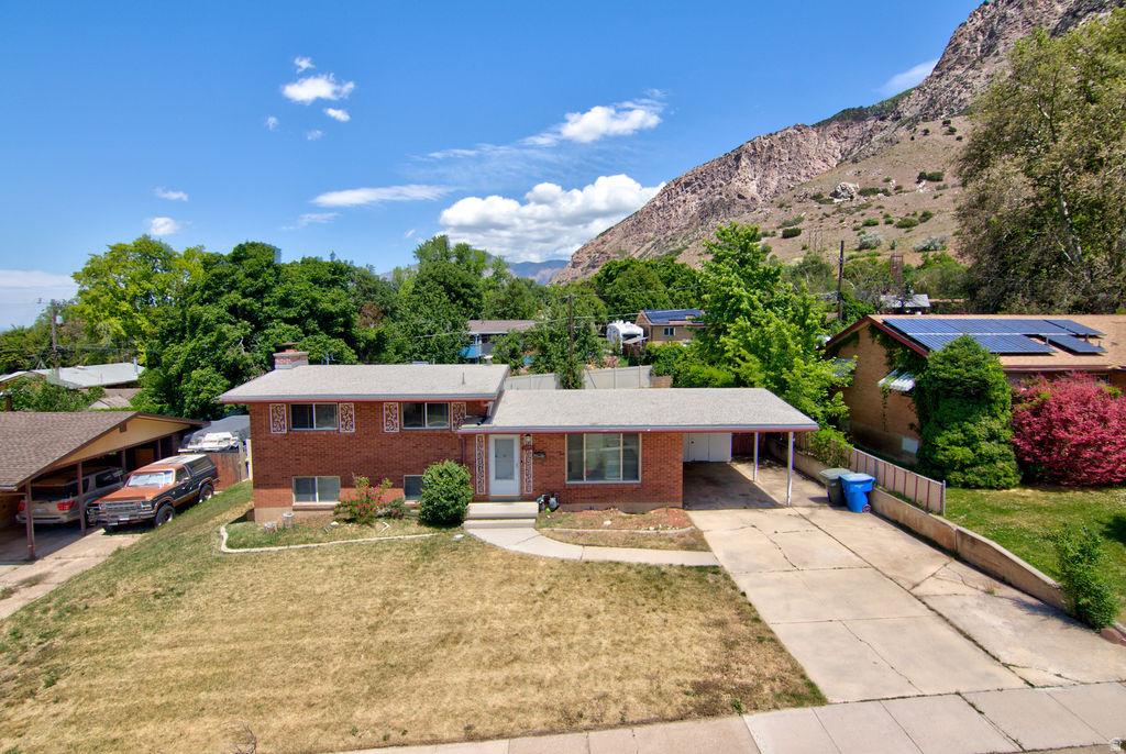 Great tri-level home in a great location! Large back yard with covered patio, walk-out basement and mountain views. Covered carport with storage sheds and side entry door to home.  2 large family rooms, neutral paint, and remodeled kitchen. This homes a large kitchen with stainless steel appliances, tile backsplash, tile flooring and painted cabinetry. Tons of storage in unfinished basement area.