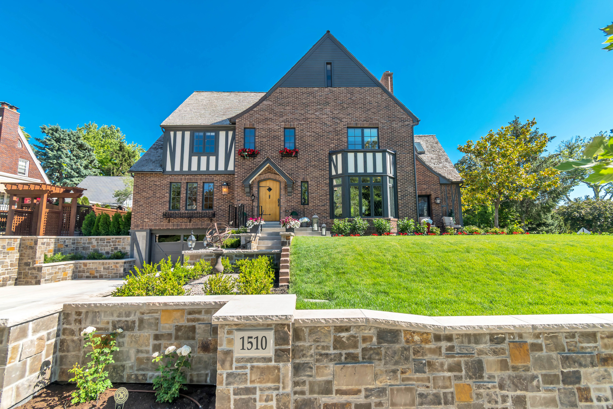 Extraordinary 100-year-old Tudor estate, meticulously restored and renovated to honor the timeless elegance of its original architecture. Situated on prestigious Yale Avenue in Yale crest, one of Utah's most beautiful and historic neighborhoods, this remarkable residence offers the rare opportunity to own a landmark home with the comfort and reliability of modern construction. The home underwent an extensive, top-to-bottom restoration, including new wiring, plumbing, foundation improvements, windows, and mechanical systems, creating a virtually new interior while preserving the character and craftsmanship of a classic Tudor manor. Every detail was thoughtfully researched and designed to reflect authentic Tudor architecture, resulting in a home rich with period-inspired features and exceptional quality. Architectural highlights include crown moldings, coved and groin-vaulted ceilings, coffered ceilings, hardwood floors, custom millwork, vaulted beam ceilings, and a dramatic three-story staircase seldom found in contemporary homes. High-end finishes are showcased throughout. The gourmet kitchen is appointed with a Wolf range, Sub-Zero refrigerator, Bosch dishwasher, marble countertops, custom cabinetry, and a butler's pantry designed for effortless entertaining. The luxurious primary suite features a private sitting area and spa-inspired bath, creating a serene retreat within the home. Additional highlights include a one-of-a-kind library showcasing original lead-glass windows, multiple family and gathering spaces, a fully permitted accessory dwelling unit (ADU) appointed with high-end appliances, and a third-floor gym. Outside, beautifully curated grounds evoke the charm of an English garden, with custom stone walls, trellises, brick-paved patios, traditional English roses, boxwoods, hydrangeas, and rare magnolia trees. A truly exceptional offering that combines historic grandeur, architectural authenticity, and modern luxury in one of Salt Lake City's most coveted neighborhoods just minutes from downtown SLC, U of U and Westminster.