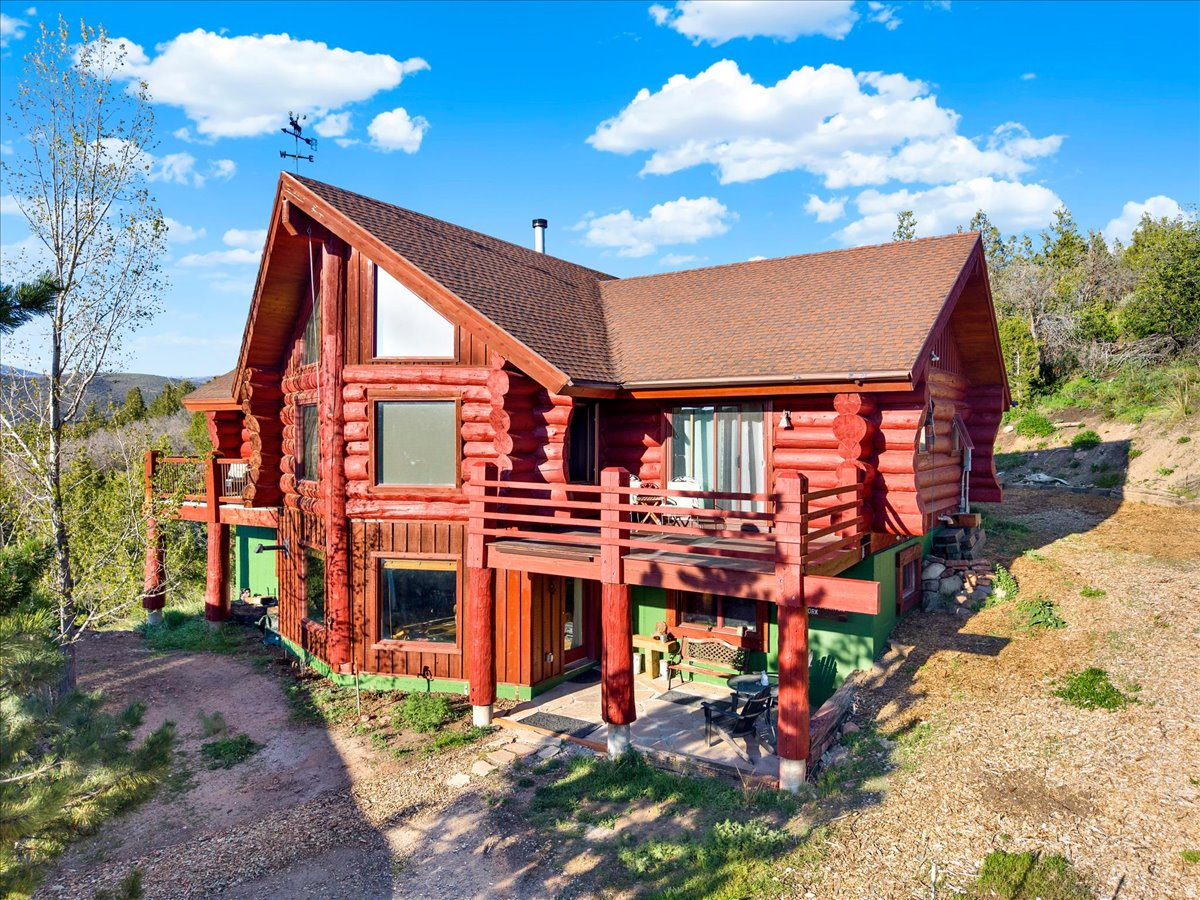 Nestled within the private community of Woodland Estates and bordering the breathtaking Uinta National Forest, this charming four-bedroom, 2.5-bath log home offers a rare opportunity to experience the serenity and beauty of mountain living on nearly six private acres. Perfectly positioned between the peaceful Provo River corridor and endless protected forestland, the property captures sweeping views across the Kamas Valley while providing year-round accessibility and exceptional privacy. Designed for both warm, cozy winter nights and long summer days in the mountains, the home embodies the ideal balance of rustic elegance and tranquil retreat. Endless miles of nearby trails invite year-round adventure, whether hiking, biking, horseback riding, ATV exploration, or snowmobiling through Utah's pristine backcountry. An oversized 4+ car garage provides exceptional space for all of your mountain lifestyle essentials, easily accommodating SUVs, ATVs, motorcycles, snowmobiles, recreational equipment, and more. Surrounded by towering pines, open skies, and the quiet beauty of nature, this property offers a true sense of freedom, tranquility, and escape -- all while remaining conveniently close to world-class amenities. Deer Valley's new East Village is less than a 20-minute drive away, and the dining, shopping, skiing, and vibrant energy of Park City are only a short drive beyond. A rare mountain sanctuary where privacy, recreation, and accessibility come together in one extraordinary setting.