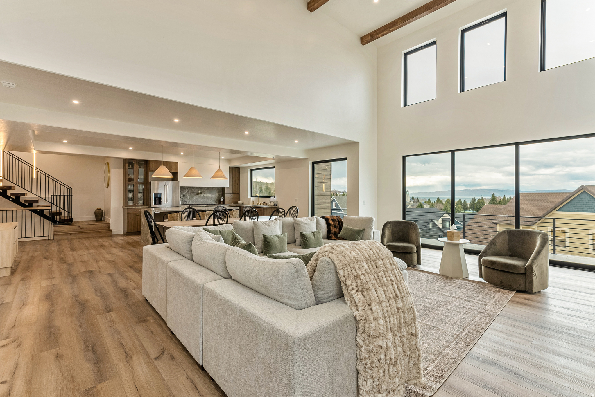 Luxury Bear Lake Retreat with Panoramic Views that's Fully Furnished with Turnkey Investment Opportunity. Perched above Bear Lake in the heart of Garden City, this stunning retreat blends luxury design, high-end finishes, and sweeping lake and mountain views in every direction. Floor-to-ceiling windows, soaring two-story vaulted ceilings, a sleek linear fireplace, and a multi-panel sliding glass door create a seamless indoor-outdoor flow to an expansive deck, ideal for sunsets, entertaining, and year-round enjoyment. The chef's kitchen is built for gathering, featuring a waterfall Calacatta quartz island, custom cabinetry, and a spacious walk-in pantry. A floating staircase with accent lighting leads to an upper level reading nook, while designer tile and upscale finishes are carried throughout the home for a refined, cohesive feel. Offering 6 bedrooms and 5 bathrooms, including 3 en-suites, this home comfortably sleeps 22+ guests. Highlights include a custom-built bunk room, dedicated theater room, and a private primary suite with its own deck and unobstructed lake views. Sold fully furnished and truly turnkey. Outdoor living continues with a spacious entertaining deck and access to a private clubhouse and pool. Walkable to the marina, grocery store, and local dining, the location offers unmatched convenience in one of Bear Lake's most desirable areas. Enjoy year-round recreation including boating and beach days, Raspberry Days festivities, winter activities, and nearby skiing at Beaver Mountain, making this a true four-season destination. A rare opportunity combining luxury, location, and strong income potential in one of Utah's most sought-after vacation markets.