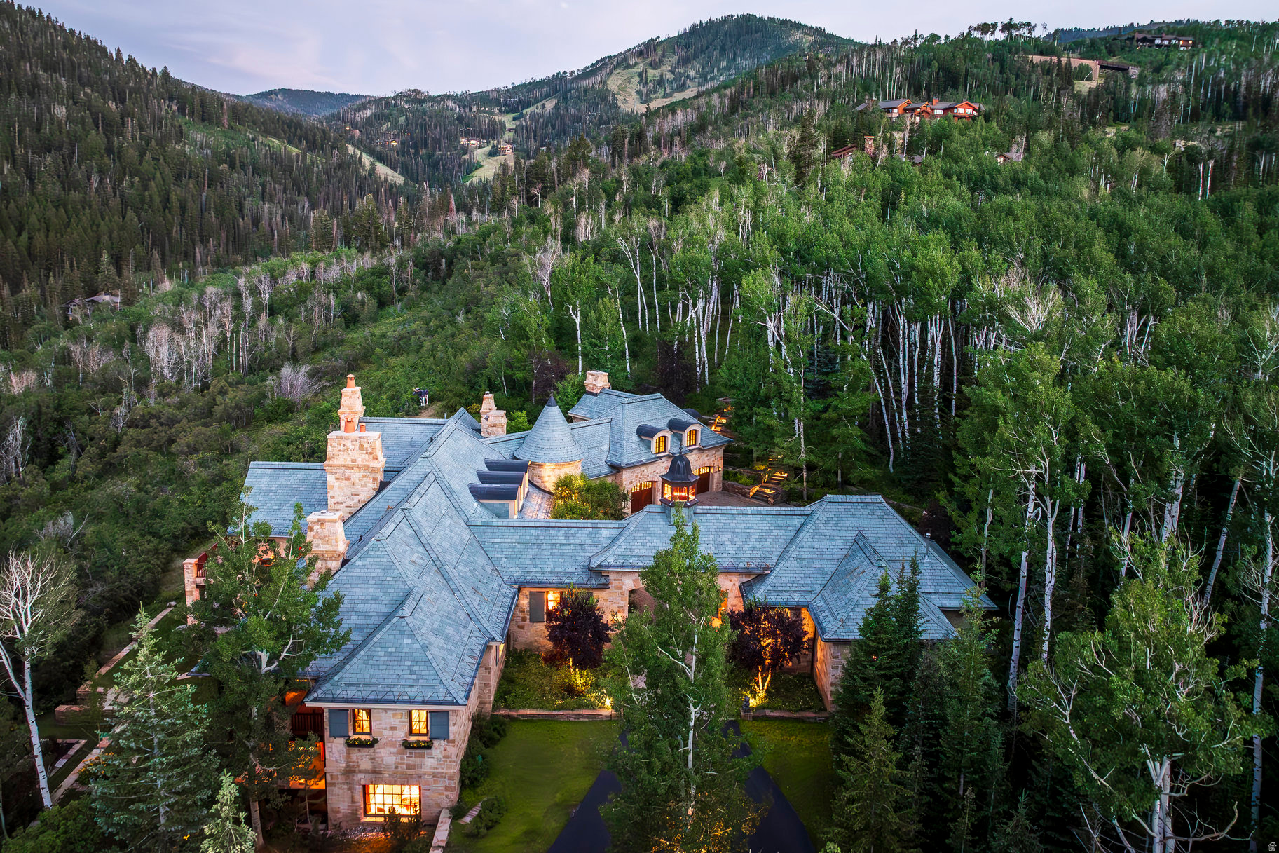 The Bastion, a master class in refined alpine living. This extraordinary ski-in/ski-out estate is located within the ultra-private, gated community of The Colony at White Pine Canyon. Set on 10+ private acres at a desirable lower elevation of 7,600 feet, sheltered from the wind and conveniently sited just two and a half minutes from the guarded entrance gate, this esteemed property offers direct, gravity-fed ski access to/from Harmony ski run, proximity to world-class mountain biking on Park City's Mid-Mountain Trail, sweeping panoramic views, and coveted year-round livability. This estate offers an exceptional sense of arrival. A wide, split-entry driveway with porte-cochre and spacious, heated auto court welcomes visitors. The property's placement within The Colony ensures rare peace and privacy; the home is set back an average of 1,500 feet from the main road, away from construction noise and traffic. The exterior is built for beauty and longevity, with low-maintenance, curated Nebraska and Oklahoma limestones, a Vermont green slate roof and mature, irrigated landscaping enhanced by subtle landscape lighting. This home is an architectural masterpiece, blending stately European elegance with rustic Western character. Rich finishes and materials sourced from around the world lend a sense of global sophistication, while Great Salt Lake-cured timbers, vaulted stone archways, and custom millwork ground the home's design in authentic mountain living. The interiors are richly layered with curated intention and artisan details speak to the home's refinement and comfort. Every detail of the interior design reflects thoughtful craftsmanship, from soaring timber-beamed ceilings and hand-laid stone archways to custom millwork and richly layered textures. This residence offers not only architectural excellence but also a rare harmony of comfort, beauty and character-ideal for those who appreciate artful living in a mountain setting.