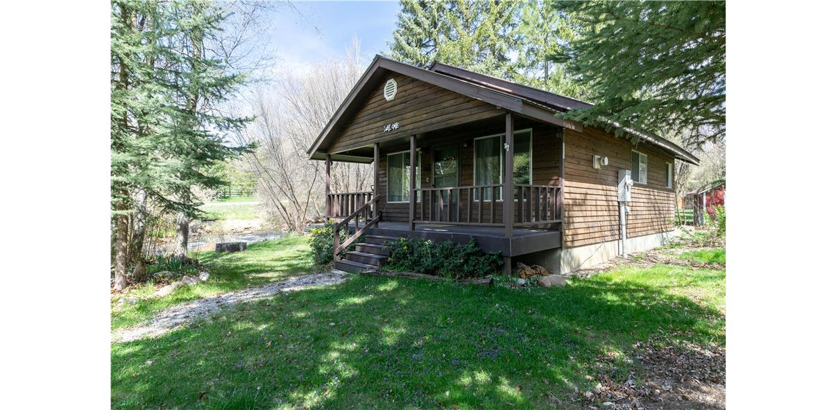 RIVER FRONTAGE and a PRICE IMPROVEMENT! Escape to nature with this charming 1-bedroom/1-bath RIVERFRONT cabin nestled along the Cub River in a beautifully wooded setting. Designed for recreational use, this cozy retreat offers the perfect place to unplug and unwind while enjoying the sights and sounds of the river just steps away. Inside, you'll find granite countertops, durable LVP flooring throughout, an on-demand water heater, and a warm propane fireplace for year-round comfort. Ideal for weekend getaways, or a peaceful basecamp for outdoor adventures, this property delivers rustic charm with modern finishes in an unbeatable natural setting. An  RV hookup on electrical panel available outside
