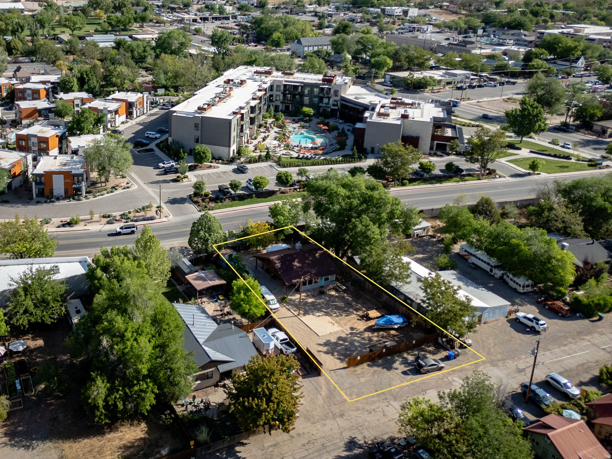 Positioned in the heart of Moab on Center Street, this C-2 Commercial Residential property offers a rare blend of flexibility, location, and future upside. Situated on a 0.24-acre lot with paved access and ample on-site parking, the property is ideally suited for a wide range of permitted uses including residential, office, or mixed-use applications. The existing single-level home has been substantially improved, with an effective build year of 2010 reflecting updated electrical, new panel, tile flooring, insulation, and window replacements. The current layout includes two bedrooms, one bathroom, a functional kitchen and living area, and a bright solarium space, making it immediately usable for residential occupancy or adaptable for professional or service-based commercial use. The fully fenced lot, gravel parking area, and strong street frontage provide both privacy and usability, while the flat terrain and surrounding red rock and mountain views enhance the setting. Utilities are fully connected, and the property includes a metal roof, basement storage with radon mitigation system, and a combination of heating and cooling options for year-round functionality. Located within Moab's C-2 zone, the property presents a compelling opportunity for investors, business owners, or those seeking a live/work configuration in a high-demand corridor. With proximity to downtown amenities, steady traffic exposure, and zoning that supports both residential and commercial integration, this property is well-positioned for long-term value and strategic redevelopment.