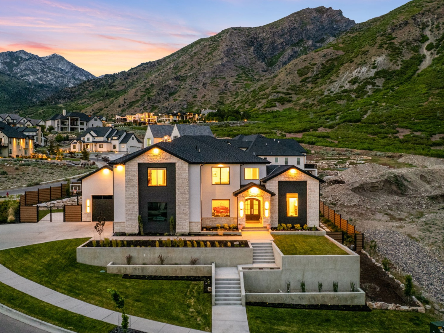 Positioned in one of Alpine's most exclusive mountainside communities, this impressive custom home blends elevated architecture, designer finishes, and breathtaking views in every direction. From the moment you step inside, you're greeted by soaring ceilings, expansive windows, and a stunning custom staircase that anchors the home with timeless design and craftsmanship.  The chef's kitchen is a true showpiece, featuring Calacatta Vagli marble countertops and full-height backsplash, premium Monogram appliances, custom white oak cabinetry, and full cast brass hardware. Designer lighting and wide-plank engineered hardwood flooring elevate the home's warm, modern aesthetic throughout.  Designed for both everyday living and entertaining, the open-concept layout seamlessly connects the kitchen, dining, and living spaces while oversized sliding glass doors create effortless indoor/outdoor flow to the private backyard retreat. The resort-style pool features a dramatic waterfall spa, expansive patios, and unobstructed mountain views that feel truly unmatched.  The luxurious primary suite offers vaulted ceilings, oversized windows framing the mountainside, a spa-inspired bathroom with a freestanding soaking tub, and a custom walk-in closet complete with built-in laundry. Thoughtful details continue throughout the home, including a beautifully designed office featuring grass cloth wallpaper by Kelly Wearstler, custom built-ins, and curated designer finishes.  The basement was designed to impress, featuring an incredible entertainment space complete with a fully equipped theater room featuring 9.2 surround sound and an 8K Sony projector, game area, fitness space, kitchenette, and ample room for hosting family and friends.  Located near Lambert Park trails and Alpine's iconic poppy fields, this home offers a rare opportunity to own a thoughtfully designed luxury residence in one of Utah's most sought-after neighborhoods.