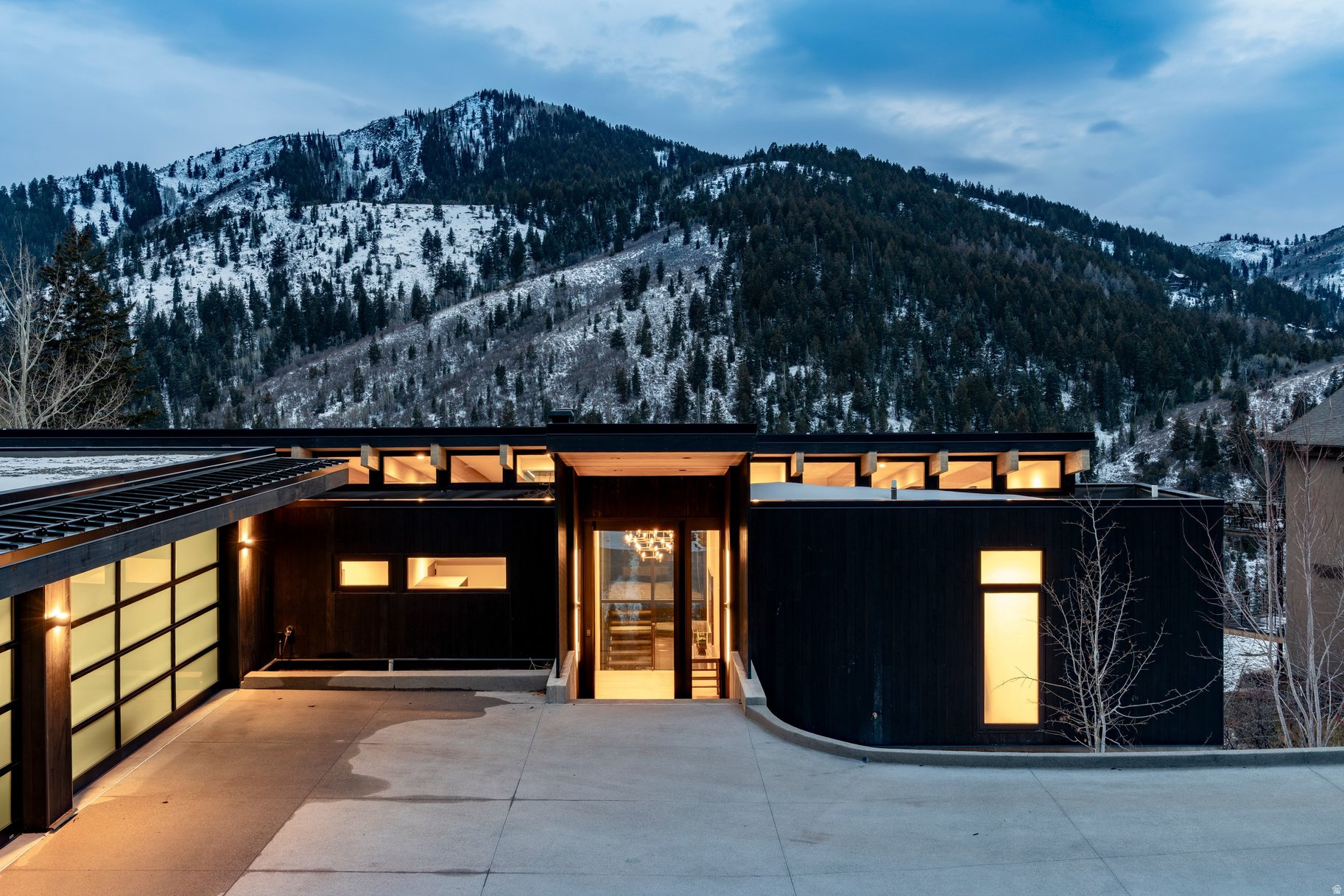 Striking mountain modern architecture meets cutting-edge efficiency in this one-of-a-kind Pinebrook residence, offering nearly 5,900 square feet of thoughtfully curated living space. Bold contemporary design blends seamlessly with exceptional comfort and performance, creating a rare opportunity in one of Park City's most convenient and sought-after neighborhoods. Perfectly positioned to capture sweeping mountain views including iconic Murdock Peak, expansive sight lines and abundant natural light create a seamless connection between indoor living spaces and the surrounding landscape. The exterior showcases dramatic Shou Sugi Ban, the traditional Japanese charred wood siding known for its durability and timeless visual impact. Inside, clean architectural lines and premium finishes define the home, highlighted by Poliform cabinetry and seamless indoor-outdoor living centered around multiple entertaining spaces and a beautifully designed deck oriented to maximize views and outdoor enjoyment. The home may be delivered furnished, offering immediate turnkey convenience. The chef's kitchen is equipped with top-tier Miele appliances and flows effortlessly into the main living areas. Luxury amenities include a private theater room, fully finished fitness space, and a serene primary suite featuring a spa-inspired steam shower retreat. Designed for year-round efficiency and comfort, the home utilizes geothermal heating and cooling powering radiant heat on both levels and the heated driveway, while solar energy further enhances sustainability and performance. Advanced smart home technology includes Crestron automation, integrated sound, and automated blinds operating on a circadian rhythm system for optimal light and energy management. Outdoor living is elevated by a striking modular pool installation, creating a rare private retreat framed by Pinebrook's scenic mountain backdrop. From your doorstep, direct access to over 1,100 acres of backcountry terrain allows for ski-out adventure and hiking, blending modern luxury living with year-round mountain recreation. Offered with furnishing flexibility, this residence presents a turnkey opportunity for buyers seeking modern luxury, efficiency, privacy, and exceptional mountain views just minutes from Park City's dining, recreation, and outdoor amenities. A rare chance to own one of Pinebrook's most architecturally distinctive and technologically advanced homes.