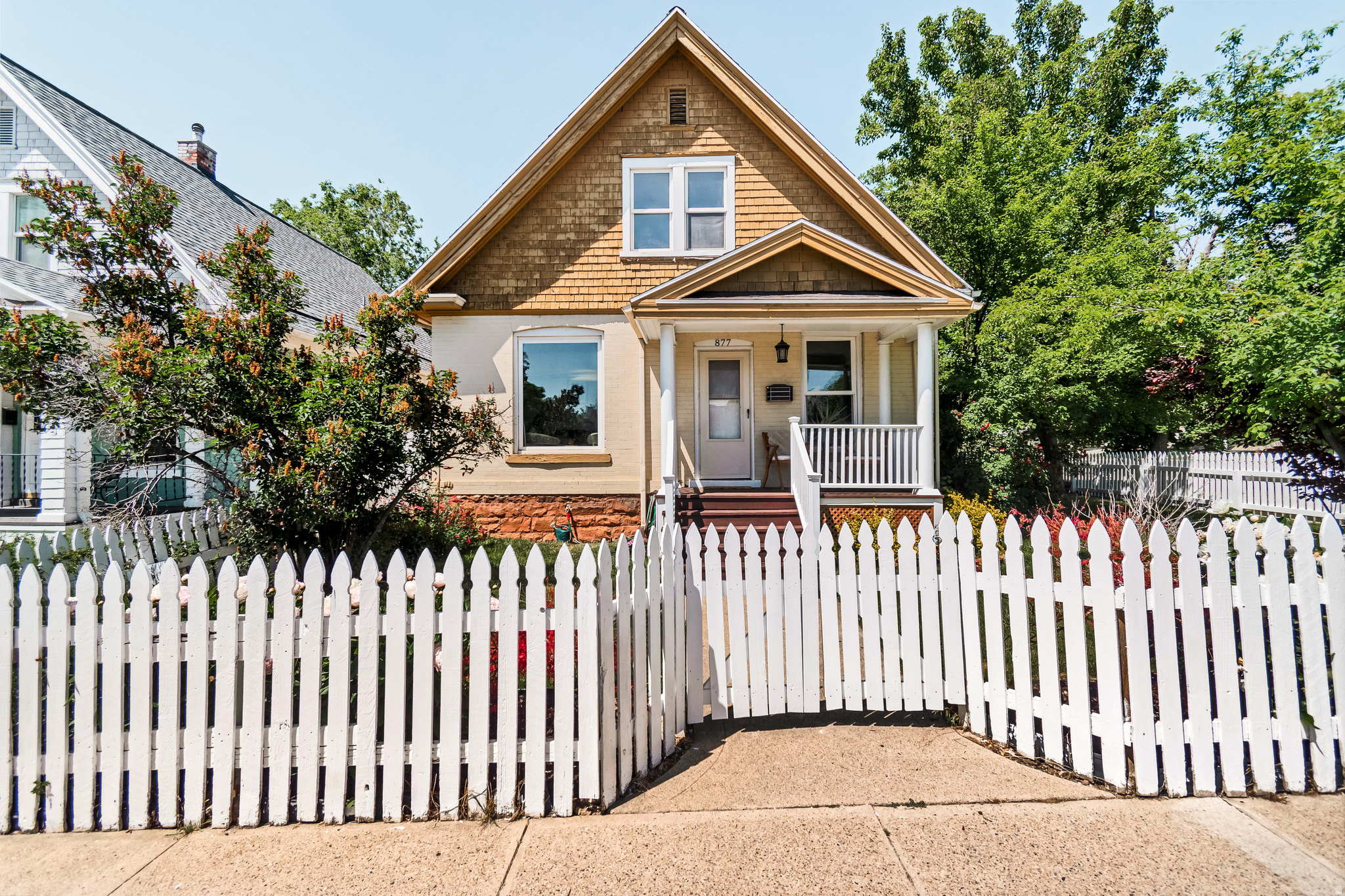 With shake singles in the dormer and a white picket fence all around, this charming home near the university is postcard perfect. We love that front porch as well as a private patio where plum trees keep summers cool and the daffodils and peonies the heart happy. Built in 1894, this home has been lovingly maintained by its owners with thoughtful improvements including updated windows and flooring, a new water heater, dishwasher, and furnace. The second bathroom has also been renovated and now functions as a  bath. There's one generous bedroom on the main floor along with two more bedrooms upstairs. The laundry has been smartly integrated into the  bath on the main which means no folding clothes in the basement here! The tall ceilings and large windows allow in loads of sunlight and the kitchen is roomy and functional. Located less than a mile from 9th & 9th, Trolley Square and a short bike ride to downtown, you may find you rarely need a car. But if you do, there's off street parking for two. If you've been looking for a turn-of-the-century home with solid bones, meaningful updates and wonderful curb appeal, then you've arrived. Welcome home.