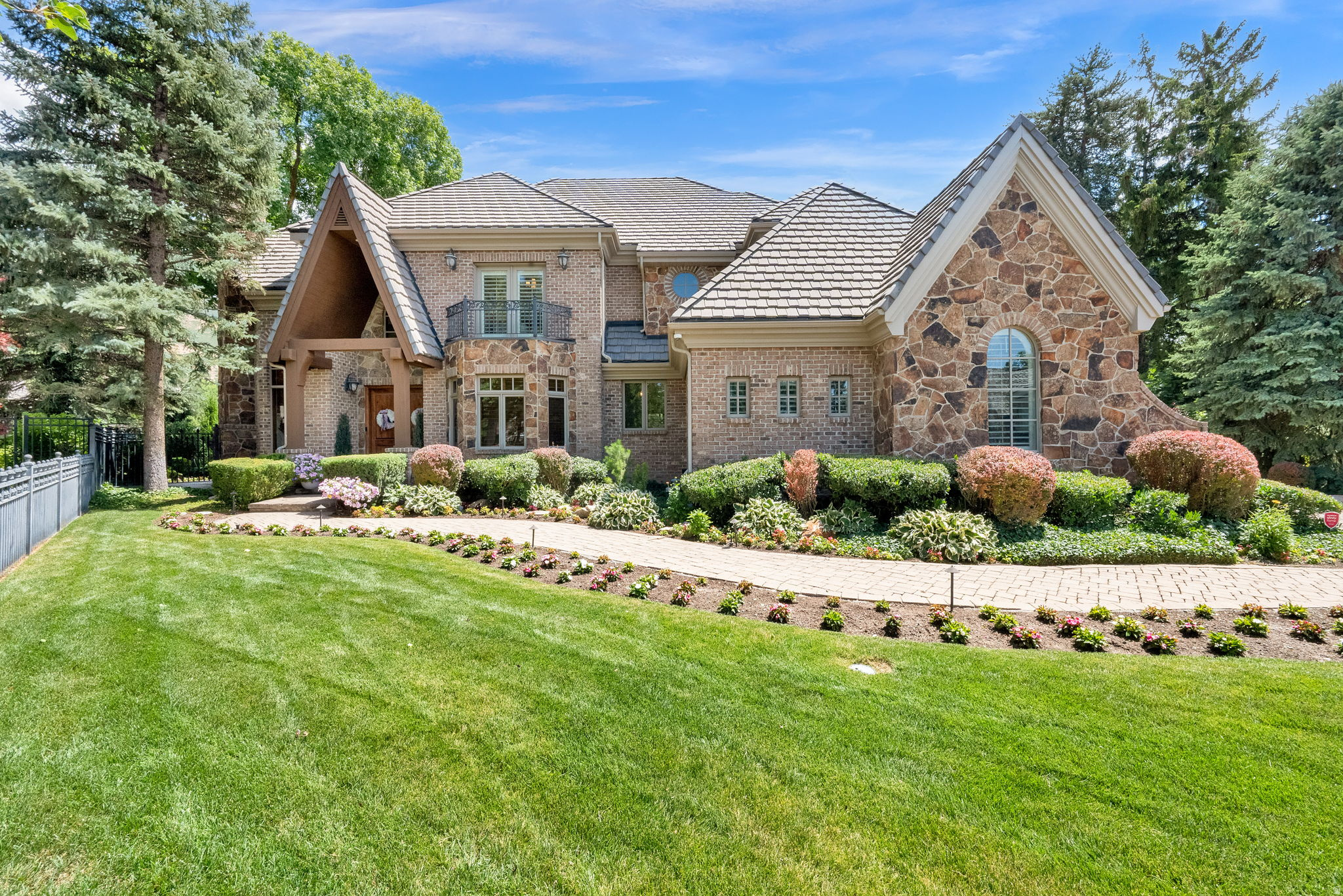 What a gorgeous home! This extraordinary custom estate is a showcase of timeless elegance, exceptional craftsmanship, and uncompromising quality. Perfectly situated on a quiet cul-de-sac with breathtaking Mt. Olympus views, this one-of-a-kind residence offers over 8,600 square feet of luxurious living where every detail has been thoughtfully designed and beautifully executed. Rich woodwork, exquisite custom millwork, stunning natural stone, soaring vaulted ceilings, handcrafted built-ins, radiant heat and solid 8-foot core wood doors create an atmosphere of warmth, sophistication, and enduring beauty throughout the home. Walls of windows flood the interior with natural light while framing spectacular mountain views. The luxurious main-level primary suite is a true sanctuary featuring vaulted ceilings, a dramatic double-sided stone fireplace, a spa-inspired bath with Jacuzzi tub, and an oversized walk-in closet. At the heart of the home, the gourmet chef's kitchen is appointed with Wolf and Sub-Zero appliances, Bosch dishwasher, built-in ice maker, beautiful custom cabinetry, and generous gathering spaces that flow effortlessly for entertaining and everyday living. The fully finished lower level with a separate walk-out entrance, expands the home's versatility with a second full kitchen, spacious family and recreation rooms, gym/game room and comfortable guest accommodations-perfect for hosting family and friends. Outdoor living is equally impressive. The professionally landscaped backyard is exceptionally private, surrounded by 8-foot walls and enhanced by extensive custom stonework, expansive paver patios and walkways, a fully equipped outdoor kitchen, wood-burning fireplace, and hot tub-creating a true backyard retreat. Completing this remarkable property is an extraordinary 5-car garage with soaring ceilings, custom cabinetry, and commercial-grade True refrigeration. Whether you're a car collector, need RV storage, or envision an indoor golf simulator or driving range, this incredible space offers endless possibilities. A rare opportunity to own one of Holladay's finest custom homes, where timeless architecture, exquisite finishes, and superior craftsmanship come together in an unforgettable luxury residence.