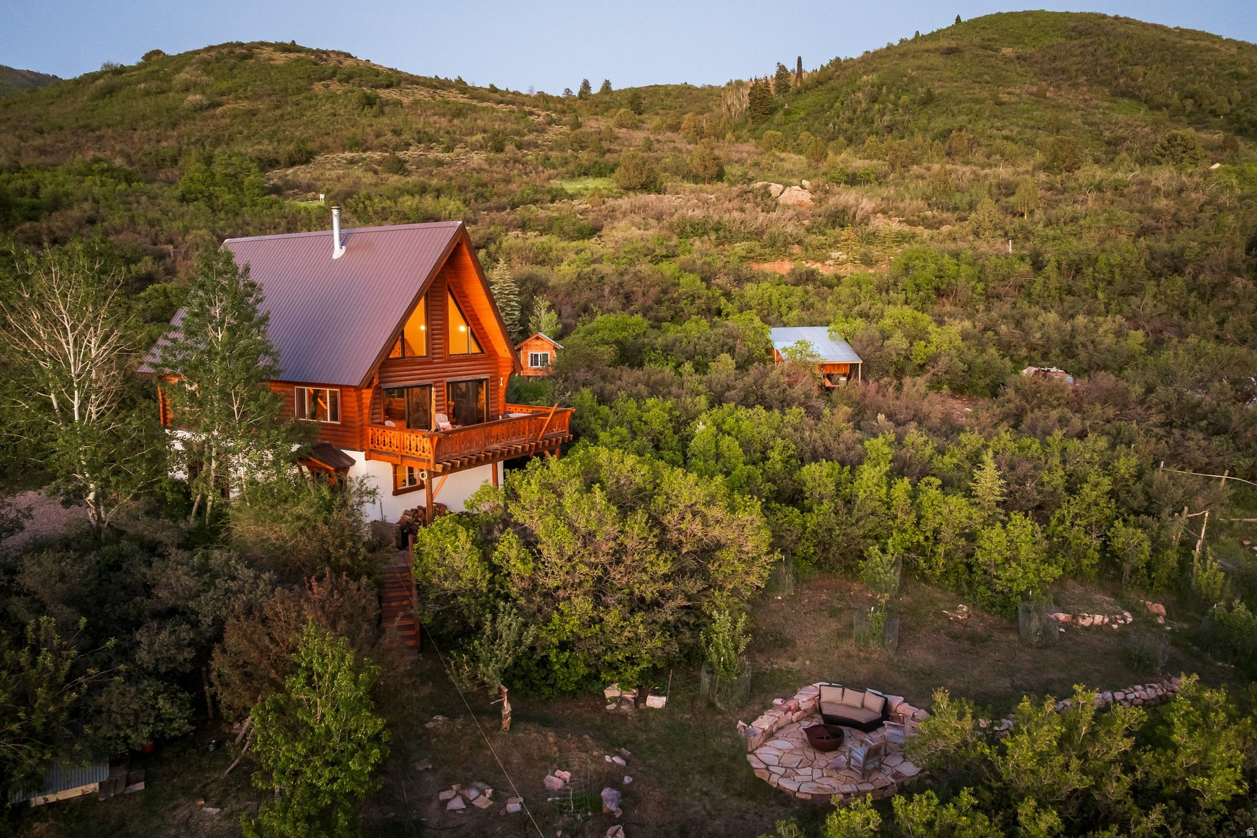 Set on 5 breathtaking acres in the Kamas Valley, this extraordinary handcrafted mountain property offers a rare blend of artisan craftsmanship, privacy, water rights, and panoramic views stretching from Mt. Timpanogos to Deer Valley and the Park City ski resorts. Designed and built by a master timber craftsman, the home showcases exceptional Swedish cope Douglas fir log construction, hand-quarried Park City sandstone floors and countertops, custom woodwork, radiant floor heat, passive solar design, and a vintage WWI-era Heatrola stove. The beautifully updated 4-bedroom residence has undergone extensive improvements from 20222026, including new Andersen windows and doors, a new metal roof, refreshed interiors, custom cabinetry and closets, updated outdoor living spaces, and professionally maintained landscaping with fruit trees, gardens, drip irrigation, and stone terraces.  Offered with Lots 83 and 84, this unique legacy property includes established Weber River water shares, two productive wells, a greenhouse with utilities and irrigation, a 4,000-gallon water storage system, and a separately recorded buildable lot with incredible ski area views. Ideal for horses, recreation, or a private mountain retreat, the property offers direct access to the Uinta Mountains for year-round adventure including hiking, horseback riding, fishing, skiing, and camping. Rarely does a property combining this level of craftsmanship, infrastructure, land, and natural beauty become available.