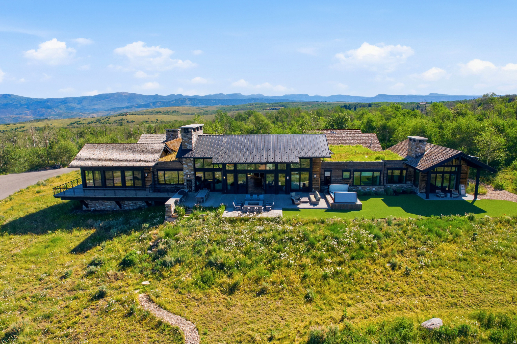 Set on 160 private acres in the heart of Wolf Creek Ranch, this extraordinary estate offers the scale and privacy of a legacy ranch with the comfort and ease of a home designed for everyday living. Design by 4C Group & Studio McGee, the entire home lives on nearly one level and is wheelchair-friendly, creating a rare combination of accessibility, functionality, and mountain modern elegance. The residence is designed for gathering, accessibility and convenience. The home boasts wide, accessible spaces and being almost entirely a single-level floor plan, making it equally suited for multi-generational living, aging in place, or welcoming guests of every age and ability. Expansive open living spaces flow effortlessly, to the outdoor entertaining areas where family and friends naturally come together. Floor-to-ceiling windows frame breathtaking panoramic views from Mount Timpanogos to Deer Valley East Village, filling the home with natural light and creating a seamless connection to the surrounding landscape. Five luxurious ensuite bedrooms are all on the main level, complemented by dedicated boys' and girls' bunk rooms on the lower level. Outside, 160 acres become your private sanctuary, with future approvals allowing for a guest house and barn--creating the opportunity for a true multi-generational family compound. Access to trails is literally steps from your heated pull through garage. Ownership also extends far beyond your property line. Enjoy 60 miles of private trails, direct access to the 2.2 million acre Uinta National Forest, private fly fishing on the Upper Provo River, community yurts, community guest house, an equestrian program, concierge services, and a full-time ranch management team. Despite its remarkable privacy, Wolf Creek Ranch is just 30 minutes from skiing, dining and shopping at Park City and Deer Valley East Village, 15 minutes from Heber Valley Airport, and 1 hour to SLC International airport.