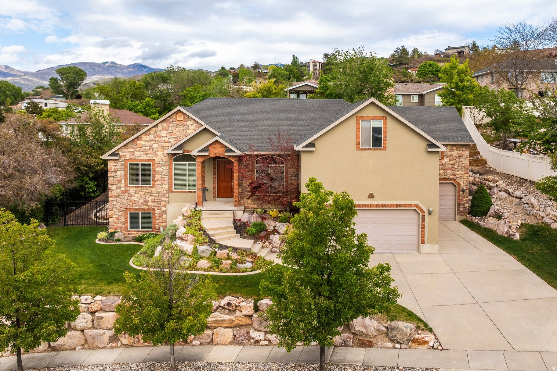 Located in a desirable hillside setting in North Salt Lake, this spacious and meticulously maintained residence offers exceptionally functional and convenient with sweeping sunset views overlooking the Great Salt Lake. This home is ideally situated just minutes from downtown Salt Lake City with immediate freeway access. The thoughtful design of the main level offers an open-concept with a seamless flow between the kitchen, family room, and spacious primary suite, creating the ideal layout. Upstairs, you'll find three large bedrooms and a full bathroom, while the fully finished walkout basement offers substantial additional living space with two more bedrooms, versatile gathering areas, and lots of storage and cold storage. The oversized 3-car garage is a standout feature, equipped with two 9-foot garage doors and a rare 10-foot door on the third bay, providing excellent flexibility for larger vehicles, recreational storage, or workshop space. Additional highlights include an intercom system throughout the home, a fully fenced yard, remarkable cleanliness and care. With its impressive size, well-executed layout, panoramic views, and prime location along the Wasatch Front, this home won't last.