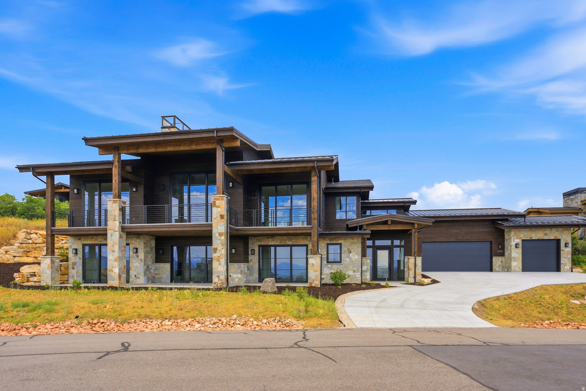 This brand new luxury build is perfectly seated on the lower hills of Golden Eagle to capture epic and inspiring views of Deer Valley ski runs and the peaks of Timpanogos, as well as the Jordanelle reservoir. This classic mountain luxury style home is built with elevated style and effortless function at its core. An oversized three car garage and grand driveway sets the stage for an elegant exterior with massive patios and decks to take in panoramic mountain vistas. The lower level has three large bedrooms with walk-out patios and a versatile living space that can accommodate a tv lounge with an adjoining alcove for a billiards room or library. A bespoke laundry room with colorful accents and beautiful stone rounds out this level, perfect for entertaining guests with comfort and privacy. The foyer features an elegant stone wall that follows the staircase to the main level. Every detail is thoughtfully crafted from beautiful stone basins in the powder bath, to hand picked quartzite slabs and light fixtures. The main level opens up to massive mountain views flooding the house with light and natural beauty. Large glass doors slide all the way across to provide indoor-outdoor living from the main room. The gourmet kitchen has custom walnut cabinetry with Thermador appliances, and double ovens. The grand focal point of this sunny living space is a floor to ceiling fireplace that tastefully grounds the room in a cozy and elegant atmosphere. Off the main room is a beautiful office space with French doors, and further down you enter the primary bedroom with stunning deer valley views and private balcony access. A stone fireplace, gorgeous oversized bathroom with a soaking tub, beautifully tiled shower and walk-in closet complete this luxurious primary suite.