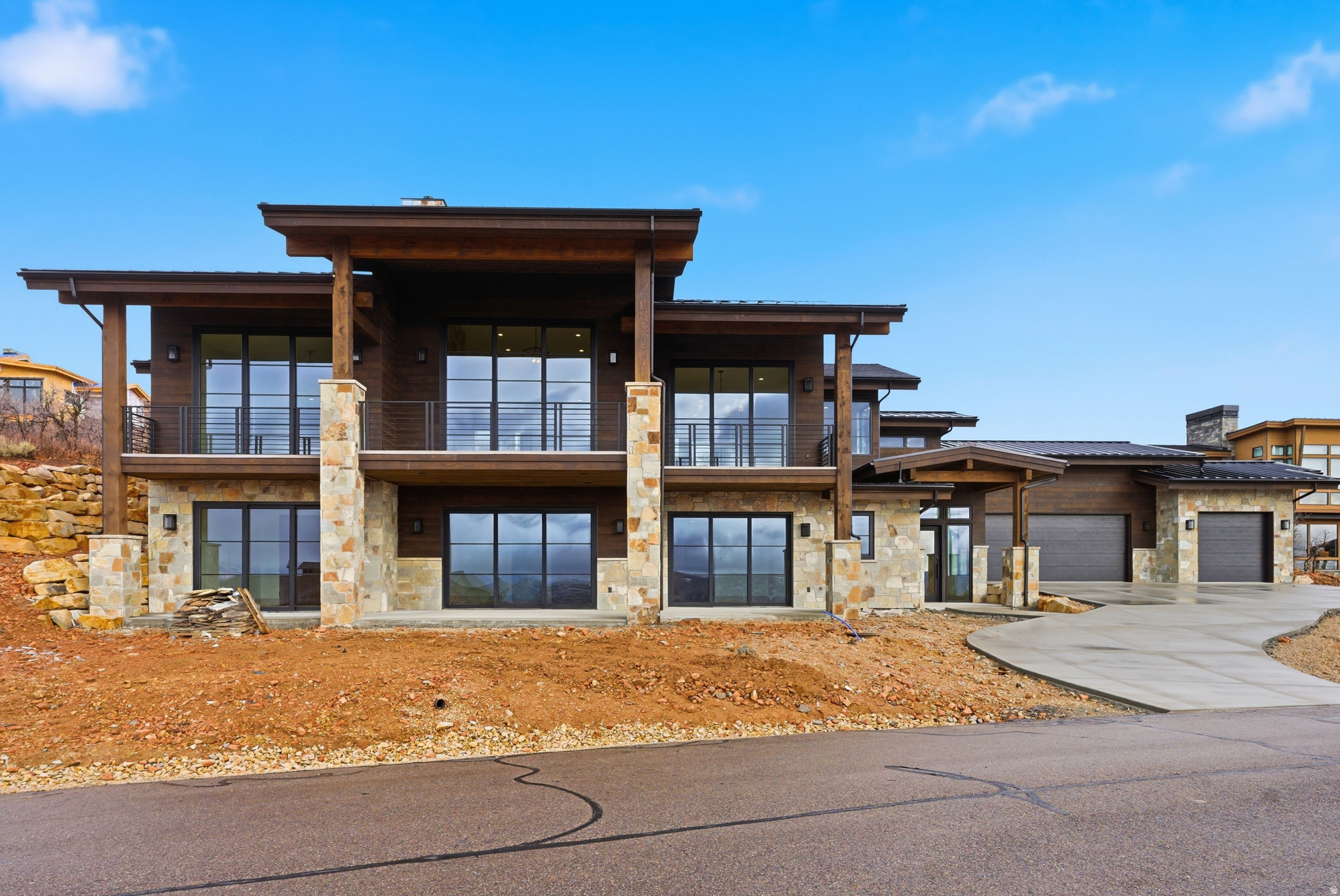 This brand new luxury build is perfectly seated on the lower hills of Golden Eagle to capture epic and inspiring views of Deer Valley ski runs and the peaks of Timpanogos, as well as the Jordanelle reservoir. This classic mountain luxury style home is built with elevated style and effortless function at its core. An oversized three car garage and grand driveway sets the stage for an elegant exterior with massive patios and decks to take in panoramic mountain vistas. The lower level has three large bedrooms with walk-out patios and a versatile living space that can accommodate a tv lounge with an adjoining alcove for a billiards room or library. A bespoke laundry room with colorful accents and beautiful stone rounds out this level, perfect for entertaining guests with comfort and privacy. The foyer features an elegant stone wall that follows the staircase to the main level. Every detail is thoughtfully crafted from beautiful stone basins in the powder bath, to hand picked quartzite slabs and light fixtures. The main level opens up to massive mountain views flooding the house with light and natural beauty. Large glass doors slide all the way across to provide indoor-outdoor living from the main room. The gourmet kitchen has custom walnut cabinetry with Thermador appliances, and double ovens. The grand focal point of this sunny living space is a floor to ceiling fireplace that tastefully grounds the room in a cozy and elegant atmosphere. Off the main room is a beautiful office space with French doors, and further down you enter the primary bedroom with stunning deer valley views and private balcony access. A stone fireplace, gorgeous oversized bathroom with a soaking tub, beautifully tiled shower and walk-in closet complete this luxurious primary suite.