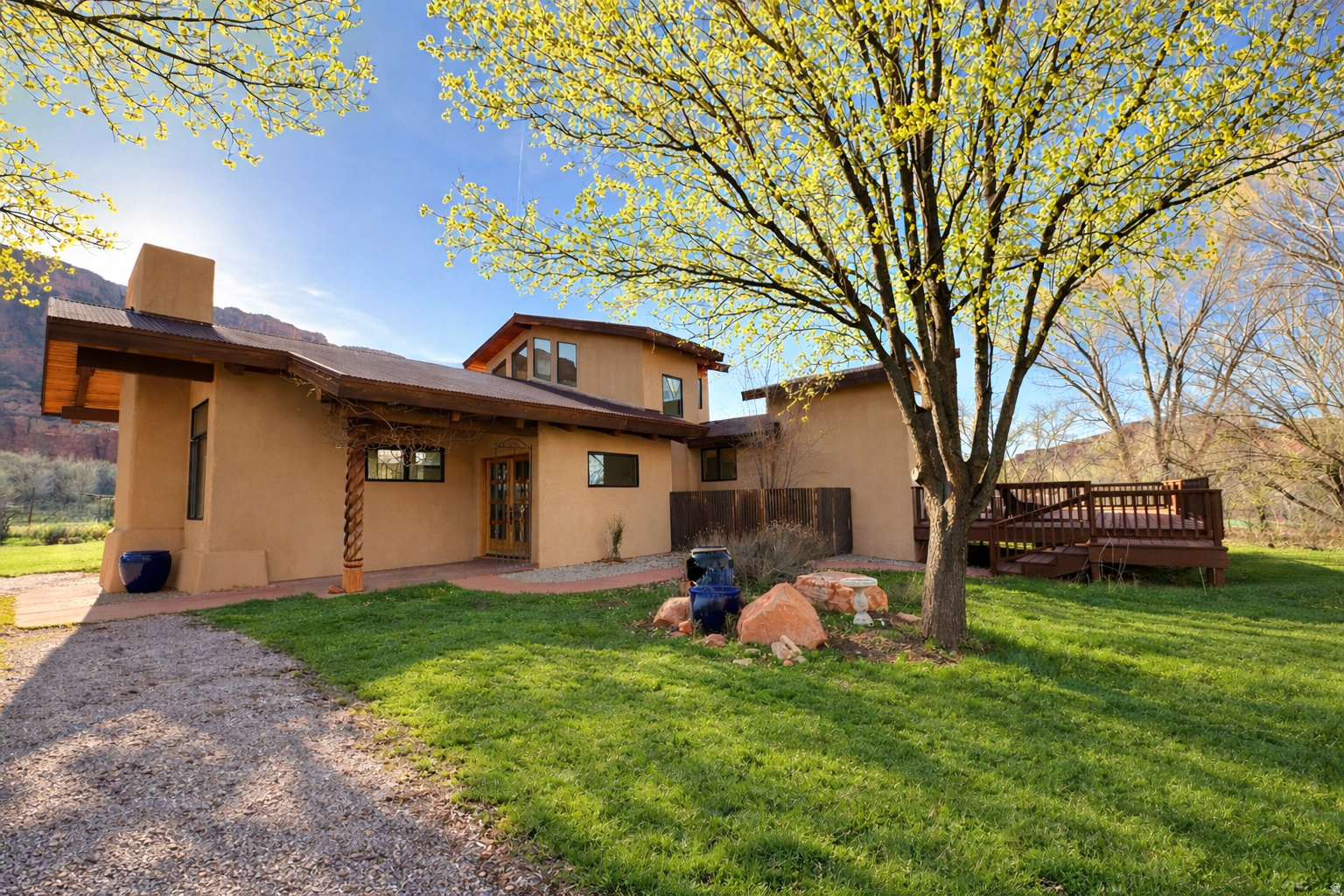 MASSIVE CLIMATE-CONTROLLED GARAGE/WORKSHOP.   Exceptional artist-designed estate on over 5 acres in Castle Valley offering privacy, craftsmanship, and breathtaking red rock desert views, including Castleton Tower, Round Mountain and the La Sal's. This unique two-story home was built by art collectors and features gallery lighting in the living room, hand-carved teakwood fireplace mantle and window panels, and adobe fireplace walls crafted by a New Mexico artisan. The home showcases Andersen wood windows, hand-carved wood entry door and outdoor columns, resurfaced oak flooring, and authentic Saltillo tile. The kitchen and primary bath feature granite countertops, while the guest bath includes quartz. A second-floor bedroom/artist studio offers dramatic 360 view windows overlooking the surrounding red rock landscape. A bright sunroom/office opens to a newly refinished wraparound deck with outdoor shower and exterior lighting. The property also includes a large fenced garden with raised beds and numerous mature shade trees. Additional highlights include a  durable metal roof, and an impressive 4,500 sq ft climate-controlled garage/workshop with two RV bays, four automobile bays, and multiple workbench areas. This versatile structure offers exceptional storage and functionality year-round -ideal for collectors, hobbyists, or creative workspaces. A rare opportunity to own a distinctive desert retreat blending art, architecture, and Castle Valley's iconic scenery. Square footage figures are provided as a courtesy estimate only and were obtained from Grand County UT and seller. Buyer is advised to obtain an independent measurement.