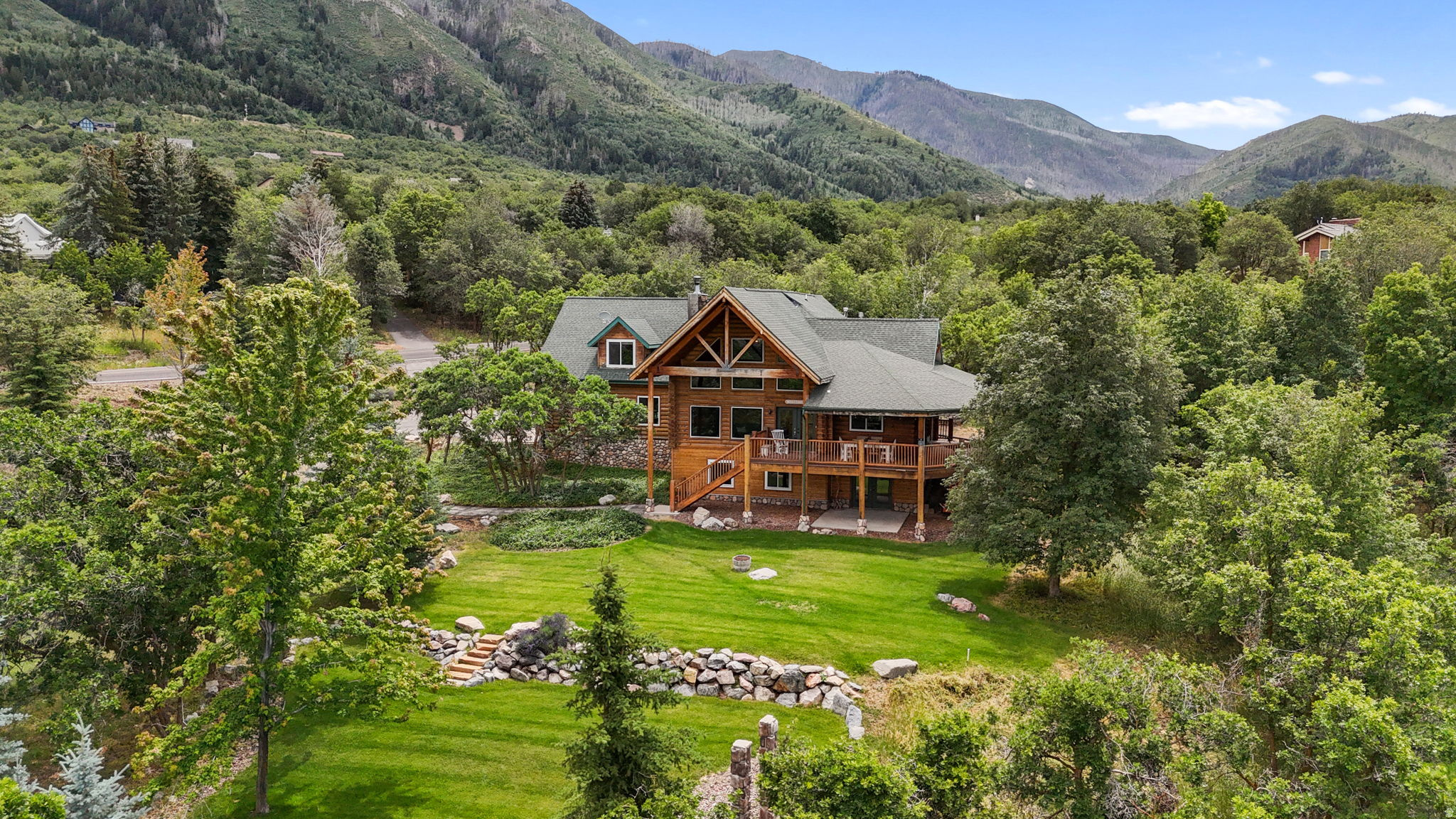 Welcome to your luxury home retreat nestled on 1.67 private acres in the heart of Woodland Hills. Surrounded by towering pines, fruit trees, and sweeping views of Utah Lake, the valley, and mountains, this is more than a home-it's a relaxing retreat designed for peace, privacy, and unforgettable moments.  Inside, you'll find soaring vaulted ceilings, rich hardwood floors, and a warm, inviting great room anchored by a wood-burning stove and million-dollar views looking out the picture-perfect windows. The remodeled kitchen blends rustic charm and modern finishes with granite countertops, a farmhouse sink, and custom stone backsplash. The private owner's suite feels like its own sanctuary with a separate level, gas fireplace, spa-style bath and built-in sauna, oversized walk-in shower, and private deck access.  The walkout basement brings in natural light and flexible living space, while the bonus room above the oversized garage adds even more room to work, play, or unwind. Outside, enjoy eating meals on your own wraparound covered decks, fenced garden, playground area, and abundant storage-everything you need for true mountain living.  Peaceful, private, and packed with character-this luxury log home relaxing retreat delivers the lifestyle buyers dream about but rarely find.  Square footage figures are provided as a courtesy estimate only and were obtained from County records. Buyer is advised to obtain an independent measurement.