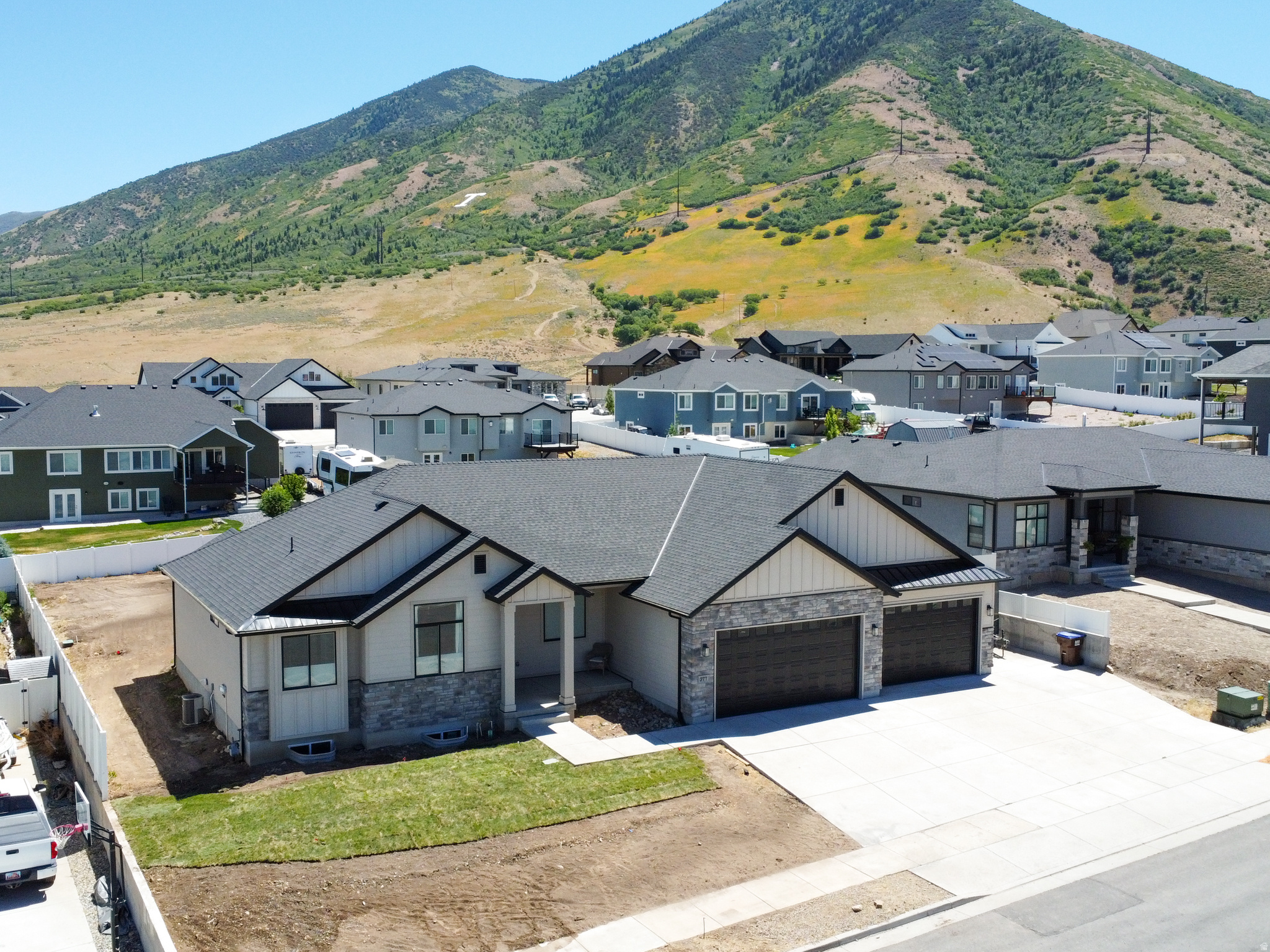 Perched on a hillside in one of the valley's most desirable locations, this beautiful rambler-style home offers breathtaking views, privacy, and direct access to outdoor recreation. Sitting on the canyon connecting Herriman and Tooele with no future development obstructing your views. Enjoy hiking, mountain biking, and dirt biking right from your driveway in this peaceful and scenic setting. Designed with both comfort and functionality in mind, this home features an exceptional floor plan with plenty of room to grow. The gourmet kitchen is a standout, showcasing upgraded slow-close cabinetry, premium appliances, a 5-burner cooktop, two pantries, abundant storage, and a massive 8' x 5' island with additional storage underneath-perfect for entertaining and everyday living. The spacious primary suite offers a luxurious retreat with dual walk-in closets, extensive built-in cabinetry, and a spa-like ensuite bathroom featuring a freestanding soaking tub. Additional conveniences include a mudroom with a coat closet, a laundry room with a utility sink, and a high-end remote-controlled fireplace. Car enthusiasts and outdoor adventurers will appreciate the oversized tandem garage with room for up to five vehicles, along with a dedicated RV pad for extra parking and storage. The large lot provides ample space for recreational vehicles, trailers, and outdoor equipment. Step outside to a covered patio and take in the stunning mountain and valley views. The backyard has been leveled with topsoil and is ready for sod or seed. Located near a golf course where neighbors often cruise the community in golf carts, this home offers a unique lifestyle that blends recreation, convenience, and tranquility. The unfinished basement features a separate exterior entrance with stairwell access and offers incredible potential for future expansion, including space for up to three additional bedrooms, a family room, or whatever best fits your needs. This is a rare opportunity to own a thoughtfully upgraded home in an unbeatable location with endless possibilities for customization and growth.