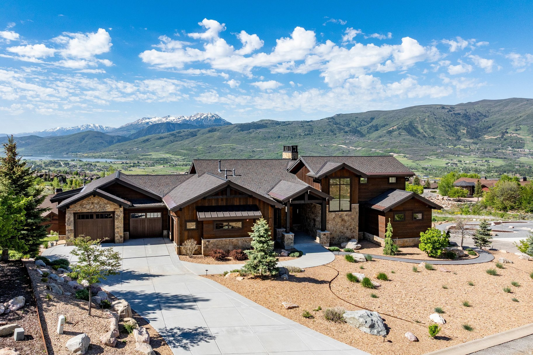 Elevated Eden Gem  Perched in one of the most coveted settings in Ogden Valley, this rare mountain retreat delivers an extraordinary lifestyle defined by privacy, comfort, and breathtaking natural beauty. Strategically positioned to capture protected 270-degree views, the home offers a daily backdrop of sweeping mountains, valley vistas, and unforgettable sunsets that can be enjoyed from nearly every room. Thoughtfully designed with a warm rustic mountain-modern aesthetic, this custom residence blends timeless craftsmanship with luxurious comfort. Rich walnut floors and stairs, solid wood-stained trim, natural stone finishes, artisan wood siding, expansive windows, radiant floor heat, and a heated driveway create an atmosphere that is both refined and welcoming. Resort-style landscaping further enhances the sense of serenity and escape. The open-concept main level was designed for effortless living and entertaining, featuring vaulted ceilings, a dramatic floor-to-ceiling stone fireplace, a chef's kitchen, and a spa-inspired primary suite designed for relaxation, and an oversized laundry room. ADA adaptability with wide doorways, spacious stairways and a primary shower with the ADA wide doors adds thoughtful functionality without compromising style. Every detail has been carefully considered to maximize coziness, privacy, and connection to the surrounding scenery. Upstairs, the secluded office provides inspiring 180-degree views-an ideal setting for productivity, creativity, or peaceful reflection. The expansive lower level offers three additional bedrooms, a spacious family room with wet bar, oversized view windows, cold storage, and an impressive 800-square-foot radiant-heated flex space perfect for a workshop, fitness area, or additional storage. Designed for year-round comfort and enjoyment, the home includes extra-deep overhangs and motorized shades that expertly manage southern and western sun exposure while preserving long days of natural light. Enjoy peaceful seclusion away from busy corridors while soaking in the hot tub surrounded by stunning views and privacy. Modern conveniences abound, including Control4 smart home electronics, heated roof panels, a generator-ready station, and an oversized three-bay garage pre-wired for EV charging with space for up to four vehicles. Located just minutes from Snowbasin Resort, Powder Mountain, and Pineview Reservoir, this exceptional property offers the perfect balance of luxury mountain living and year-round recreation. A home of this caliber must be experienced in person to fully appreciate the craftsmanship, thoughtful design, peaceful setting, and spectacular scenery. Schedule your private tour today.