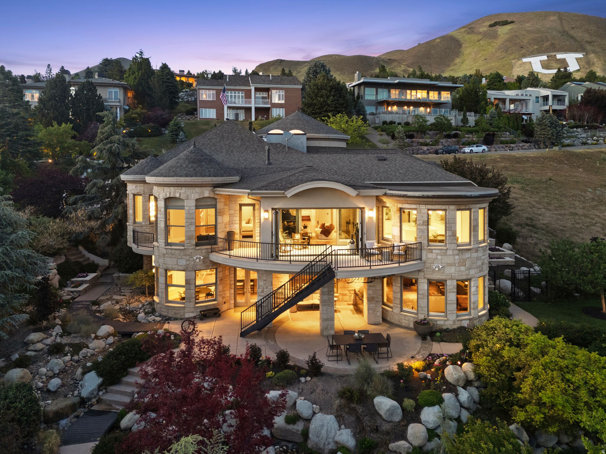 Perched high within the prestigious gated community of Federal Pointe, this extraordinary estate offers some of the most breathtaking, unobstructed panoramic views in all of Salt Lake City. From the sparkling city skyline to the surrounding mountains and valley below, the views are truly irreplaceable and nearly impossible to duplicate.  Meticulously built with timeless craftsmanship and exceptional attention to detail, this remarkable residence is both a luxury home and a true work of art. Expansive floor-to-ceiling windows flood the home with natural light, creating an airy, open atmosphere while perfectly framing the spectacular scenery from nearly every room.  A grand double-door entry welcomes you into elegant formal living and dining spaces, while comfortable gathering areas seamlessly connect to the solarium and multiple view decks overlooking the valley and beautifully landscaped grounds. The chef's kitchen features white cabinetry, granite countertops, a large center island, bay window dining nook, Sub-Zero refrigerator, and premium Miele appliances including double dishwashers.  The luxurious primary suite offers a private retreat with sitting alcove, private deck, dual closets, and a beautiful soaker tub. The other four bedrooms feature en suite bathrooms, providing comfort and privacy for family and guests.  The fully walk-out lower level lives nothing like a basement. Surrounded by floor-to-ceiling windows and extraordinary views, the space feels bright, open, and completely above ground. Designed for entertaining and multigenerational living, it features a spacious recreation area, full second kitchen with quarter-sawn oak cabinetry, Sub-Zero refrigerator, stainless steel appliances, theater space, an office, bedrooms, and additional laundry.  Outdoor living is equally captivating. The whimsical backyard feels like a private sanctuary with lush professional landscaping by Landform Design, multiple decks and sitting areas, built-in barbecue, gas firepit, and a peaceful man made creek running through the grounds, creating a serene setting enhanced by the soothing sound of flowing water. Whether enjoying sunset views from the decks or relaxing fireside beneath the trees, every space was designed to evoke peace and beauty.  Additional features include smart home technology, upgraded lighting and hardwood floors, surround sound throughout, heated driveway and walkways, and timeless natural stone and brick exterior.  Ideally located just 12 minutes from downtown Salt Lake City, 8 minutes from the University of Utah, approximately 15 minutes to Salt Lake International Airport, and moments from Bonneville Shoreline Trail access, world-class hiking, biking, skiing, dining, and recreation.  Call for a private tour.