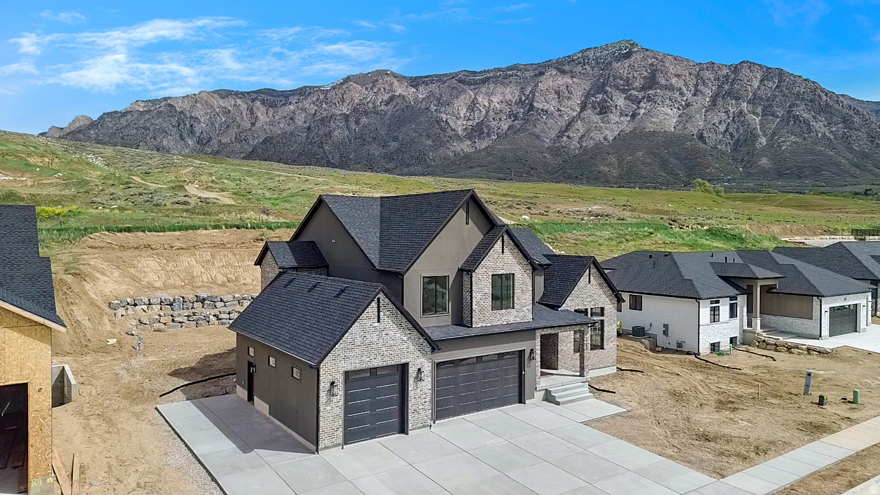 This custom home delivers unobstructed views of Ben Lomond Peak, the valley, and the lake, paired with a level of finish and lot usability that's hard to find. The open, light-filled layout features expansive windows and high-end details throughout, including custom cabinetry with under-cabinet lighting, a gourmet kitchen with double-thick quartz countertops, stainless steel appliances, and a hidden butler's pantry.  The primary suite offers a true retreat with a spa-style bath, separate tub/shower, and a large walk-in closet with laundry hookups. 9' ceilings upstairs and in the fully finished basement create a spacious, elevated feel, complemented by custom tile work throughout.  Enjoy no backyard neighbors and a rare, large flat lot. Ideal for a future pool or sport court. The covered patio is perfectly positioned to take in the mountain views.  Additional highlights include a double-deep 3-car garage and a 36' RV pad leaving you plenty of space for all the toys.  Homes at this price point with this combination of views, upgrades, and usable land are limited.