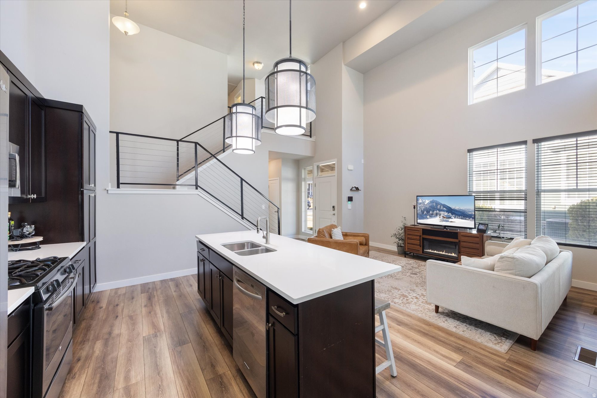 Welcome home to this well-kept North Shore Village townhome that truly lives like a single-family residence. Be sure to click the tour for a full video walkthrough of the space. Step into a welcoming great room highlighted by soaring two-story ceilings and expansive windows that flood the home with natural sunlight. The primary bedroom is conveniently located on the main level, while two additional bedrooms and a full bathroom are upstairs-perfect for guests, family, or a home office setup. The finished basement adds even more flexibility with a bonus room ideal for storage, a craft space, playroom, or hobby area. A security system and cameras are included for added peace of mind. Enjoy a prime location near Tulip Park, Harmons, and the North Shore of Oquirrh Lake, with easy access to Bangerter Highway and Mountain View Corridor. Residents also enjoy all that Daybreak has to offer, including swimming and splash pools, community gardens, sports courts, outdoor summer concerts, farmers markets, boating privileges on Oquirrh Lake, and so much more.*Buyer is advised to obtain an independent measurement. Buyer/Buyers Agent to verify all info including sq. ft.