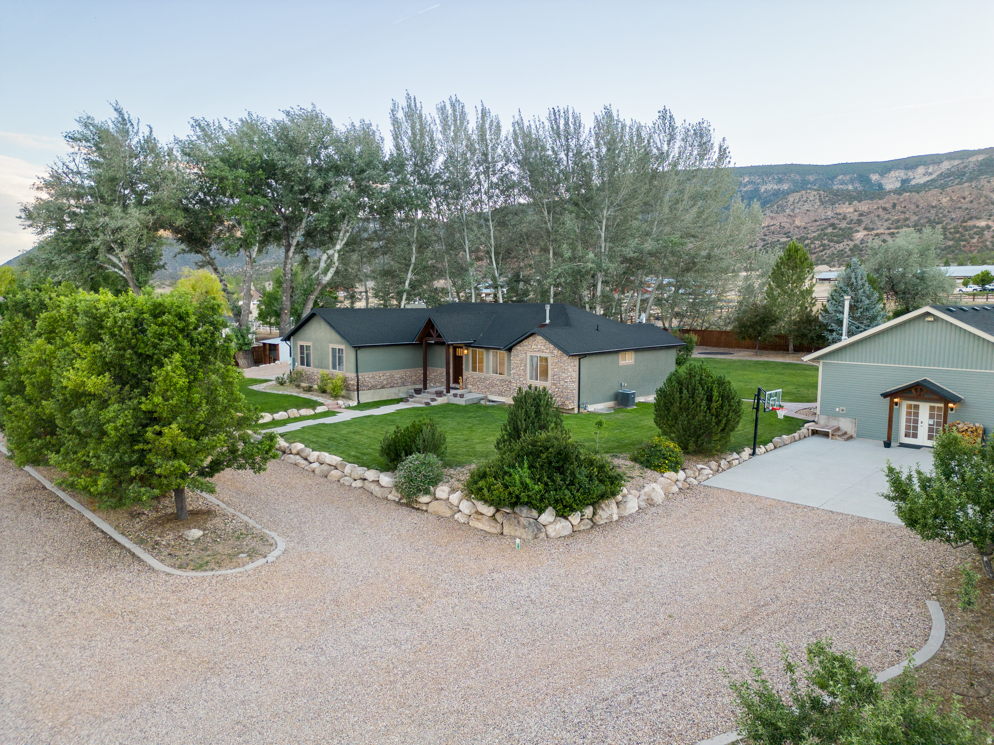 Completely remodeled and packed with upgrades, this one-of-a-kind property offers luxury, flexibility, and endless possibilities. The main home features top-of-the-line cabinetry, flooring, and appliances (sink, appliances and quartz countertops will be installed before closing). Enjoy a walk-in shower, a fun slide to the basement, a home theater with projector, oversized cold storage, and hookups for two washers and dryers on the main floor. All window shades are included, with remote-controlled shades throughout the upstairs and blackout in all bedrooms and in the ADU. Additional upgrades include solar power, a water softener, and an instant water heater.  The basement includes a separate 3-bedroom/1 ba ADU/mother-in-law apartment with its own entrance, playroom, large laundry/craft room, and wood stove.   An additional detached ADU offers an additional 1200 sf of living space with a full kitchen (appliances included), bathroom, laundry, wood stove with fridge, washer and dryer included.  Outside, you'll find a private retreat with a stream, fire pit, swing set, trampoline, salt water hot tub, fenced garden, chicken coop w/electricity, dog run, powered workshop, and two wood sheds stocked with years of firewood. The property also includes full RV hookups with power, water, and sewer dump access, plus a 40-foot shipping container for additional storage and .25 acres the land could be used for horses or livestock if wanted. This rare property offers luxury living, multi-generational flexibility, income potential, and exceptional outdoor amenities all in one.  SEE VIRTUAL TOUR BELOW! Irrigation on the property available with purchase of water shares.  Square footage figures are provided as a courtesy estimate only and were obtained from the county.  Buyer is advised to obtain an independent measurement.