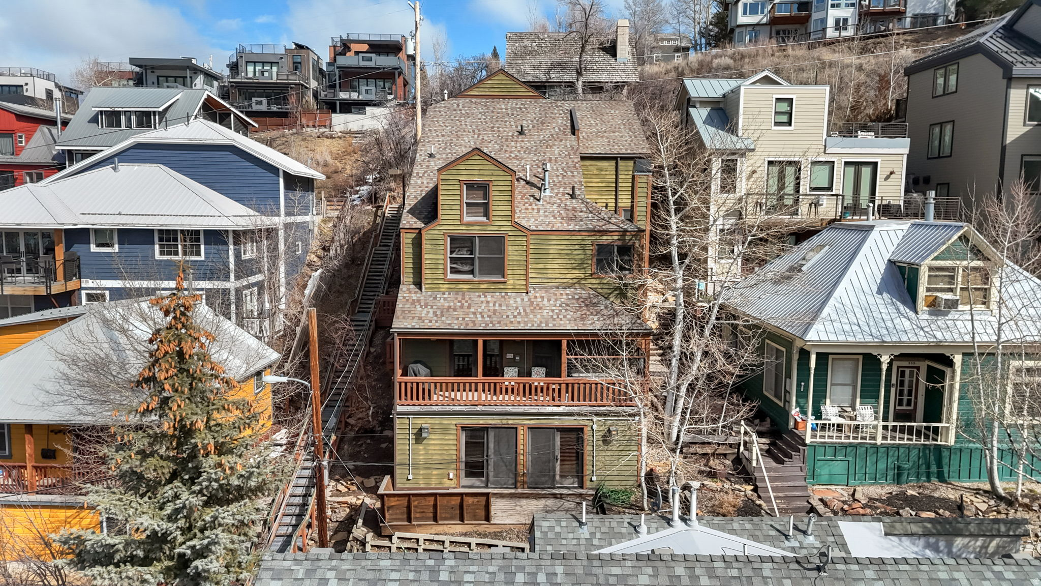 Located in the heart of Park City's coveted Old Town neighborhood, this meticulously maintained residence blends timeless mountain architecture with exceptional modern comfort. Perfectly positioned just steps from the iconic Shorty Stairs, the home offers direct walkable access to Main Street's renowned restaurants, galleries, and shopping while capturing beautiful views of Old Town and Park City Mountain Resort. Spanning more than 3,700 square feet across multiple levels and serviced by a private elevator, the home was thoughtfully built on more than one traditional Old Town lot, allowing for larger living spaces, generous bedrooms, and an ideal layout for both entertaining and everyday living. The main living area is designed for gathering, featuring a spacious great room with a gas fireplace that flows seamlessly into a chef's kitchen equipped with premium Viking gas appliances, granite countertops, and a distinctive copper island and backsplash. The kitchen opens to both formal and casual dining spaces, creating an inviting environment for hosting family and guests. Five well-appointed bedrooms, three with ensuite bathrooms, provide comfort and privacy, while additional den and media rooms offer flexible spaces for work, relaxation, or movie nights after a day on the slopes. Outdoor living is equally impressive with two balconies and multiple entrances to the home, allowing easy access throughout the property. Enjoy the private hot tub after skiing or take in the stunning views overlooking Old Town and Park City Mountain. Designed with both luxury and practicality in mind, the home features high-end finishes throughout, solid soundproof construction, integrated audio speakers, CAT6 wiring, reverse osmosis filtration, a new water softener system, an emergency water shutoff valve, and a brand-new furnace with a humidifier. Additional highlights include a two-car garage and a heated two-car driveway, providing rare convenience in Old Town. With its exceptional construction, spacious design, and unbeatable location just minutes from the slopes and steps from Main Street, this home offers a rare opportunity to experience the very best of Park City living.