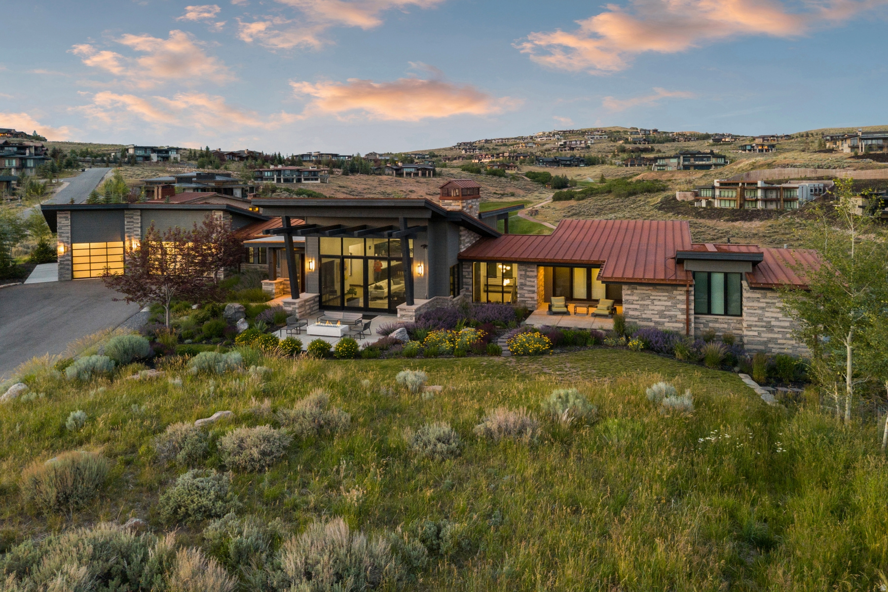 The Ultimate Promontory Home for Entertaining, Wellness & Golf -- Designed for effortless entertaining and everyday luxury, this exceptional Promontory residence offers an ideal blend of indoor comfort, outdoor living, and resort-style amenities. Located at 8786 N Promontory Ridge Road, the home captures ski resort views from the front and overlooks the 14th fairway of the Pete Dye Canyon Course from the expansive rear patios and decks. The thoughtfully designed floor plan features four bedrooms, including two main-level suites, with spacious gathering areas that seamlessly connect to multiple covered outdoor living spaces. Whether hosting intimate dinners or large celebrations, you'll appreciate the outdoor dining area, three fire features, hot tub, and abundant seating designed to enjoy every season. The walkout lower level is equally impressive, anchored by a wellness and recreation space featuring a golf simulator, fitness area, infrared sauna, steam shower, and cold plunge. The flexible layout also provides the opportunity to convert this area into additional bunk space or a recreation room for larger gatherings. Additional highlights include a dog run, generous storage, and a Golf Membership available with the purchase, providing immediate access to Promontory's award-winning golf courses, clubhouses, dining, spa, fitness, family amenities, and more. A rare opportunity to own a home that lives as comfortably as it entertains.