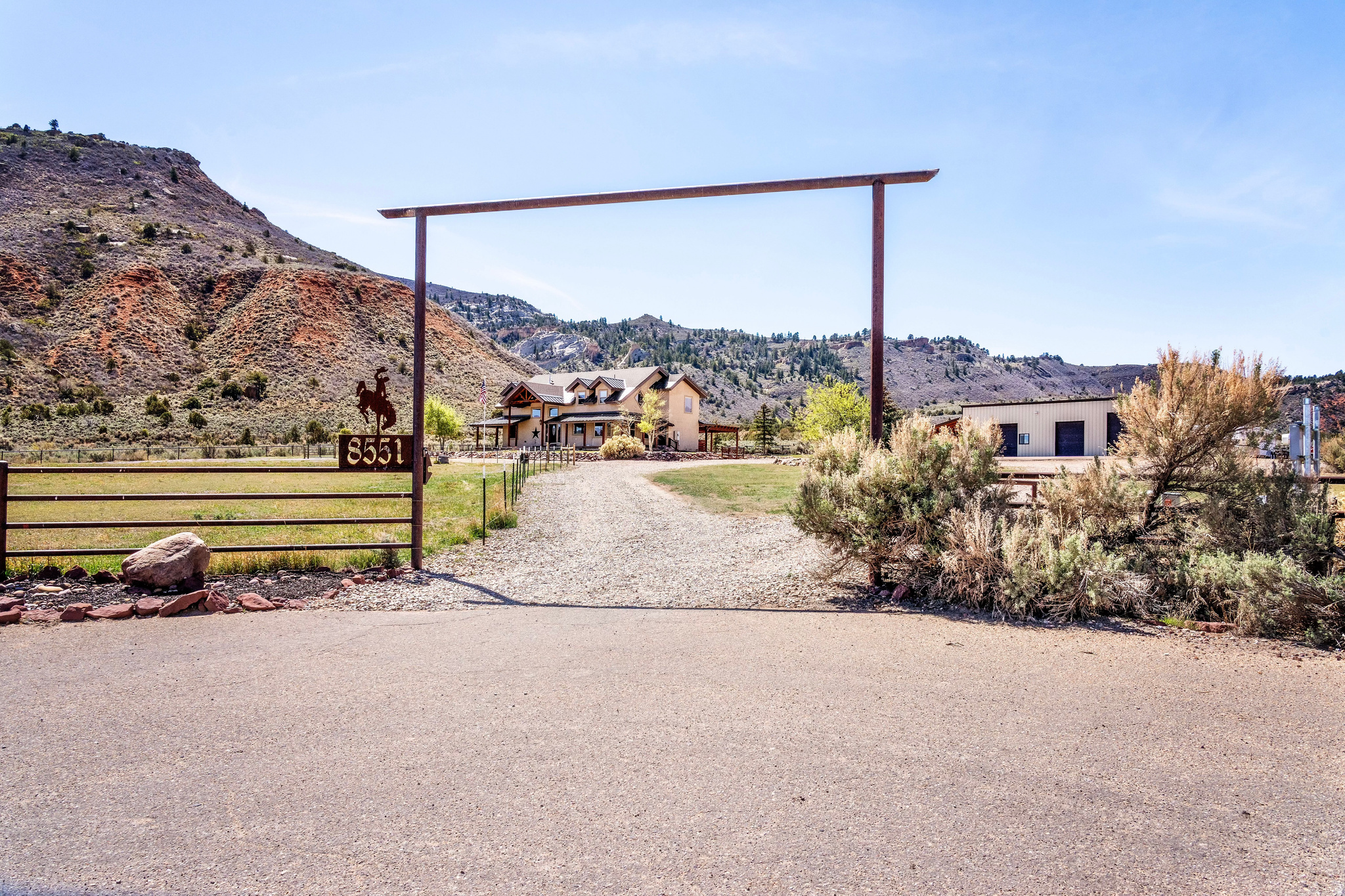 Tucked into the heart of Dry Fork Canyon, this remarkable 8-acre estate offers more than a home-it delivers a lifestyle surrounded by some of Vernal's most iconic scenery. Towering Navajo sandstone cliffs create a dramatic backdrop, while nearby access to McConkie Ranch Petroglyphs, the Flume and Narrow trailheads, Red Cloud Loop, Flaming Gorge, Red Fleet Reservoir & Ashley Gorge via Ferrata puts outdoor adventure close by. A covered wrap-around porch welcomes you into a thoughtfully designed residence where craftsmanship and comfort meet. Inside, the great room makes an unforgettable first impression with soaring 24-foot tongue-and-groove vaulted ceilings, expansive wood-framed windows, and a striking floor-to-ceiling stone fireplace, complemented by a Blaze King wood catalytic stove. Natural light and panoramic canyon views fill the space, creating a true sense of mountain elegance. The kitchen serves as the heart of the home, featuring granite and quartz countertops, custom alder cabinetry with built-in details, a gas range, and a new updated refrigerator. Whether gathered at the breakfast bar or seated in the charming circular dining nook, every space is designed to take in the surrounding views. The main-level primary suite offers a peaceful retreat, complete with a spa-inspired bathroom featuring a freestanding soaking tub, walk-in shower, and walk-in closet. With four bedrooms and two-and-a-half bathrooms, the home balances comfortable private spaces with inviting areas for entertaining. Designed with both function and versatility in mind, the property is fully equipped for animals and hobbies alike. Much of the acreage is pipe-fenced, with established pasture on the front and south side. This is a fully fenced horse property that includes a 20' x 24' lean-to. The impressive 3,500 sq. ft. red iron shop with attached lean-to provides exceptional workspace, featuring five bay doors, 200-amp separate service, commercial-grade wiring, a 50-amp RV hookup, and dedicated areas for storage, projects, and even a custom sauna. Outdoor living is just as exceptional, with a stamped patio, pergola, and custom rock firepit area perfect for enjoying peaceful canyon evenings. Additional amenities include a high-fenced garden area, chicken coop with run, covered hay storage, multiple water hydrants, and ample storage throughout. The well provides 4.73 ac ft of water. The property is also supported by 1,000-gallon and 500-gallon propane tanks for added convenience. This is a rare opportunity to own a private canyon retreat that seamlessly blends refined living with the rugged beauty of the surrounding landscape. Buyer to verify all information, including square footage.